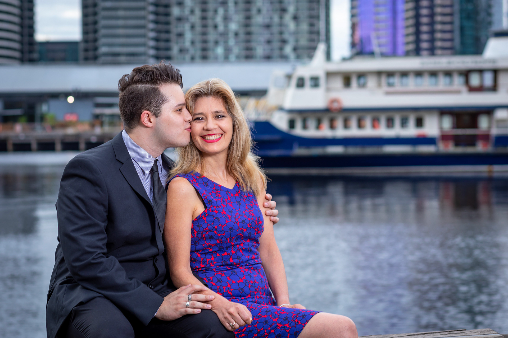 Parents kissing their child beside a waterfront