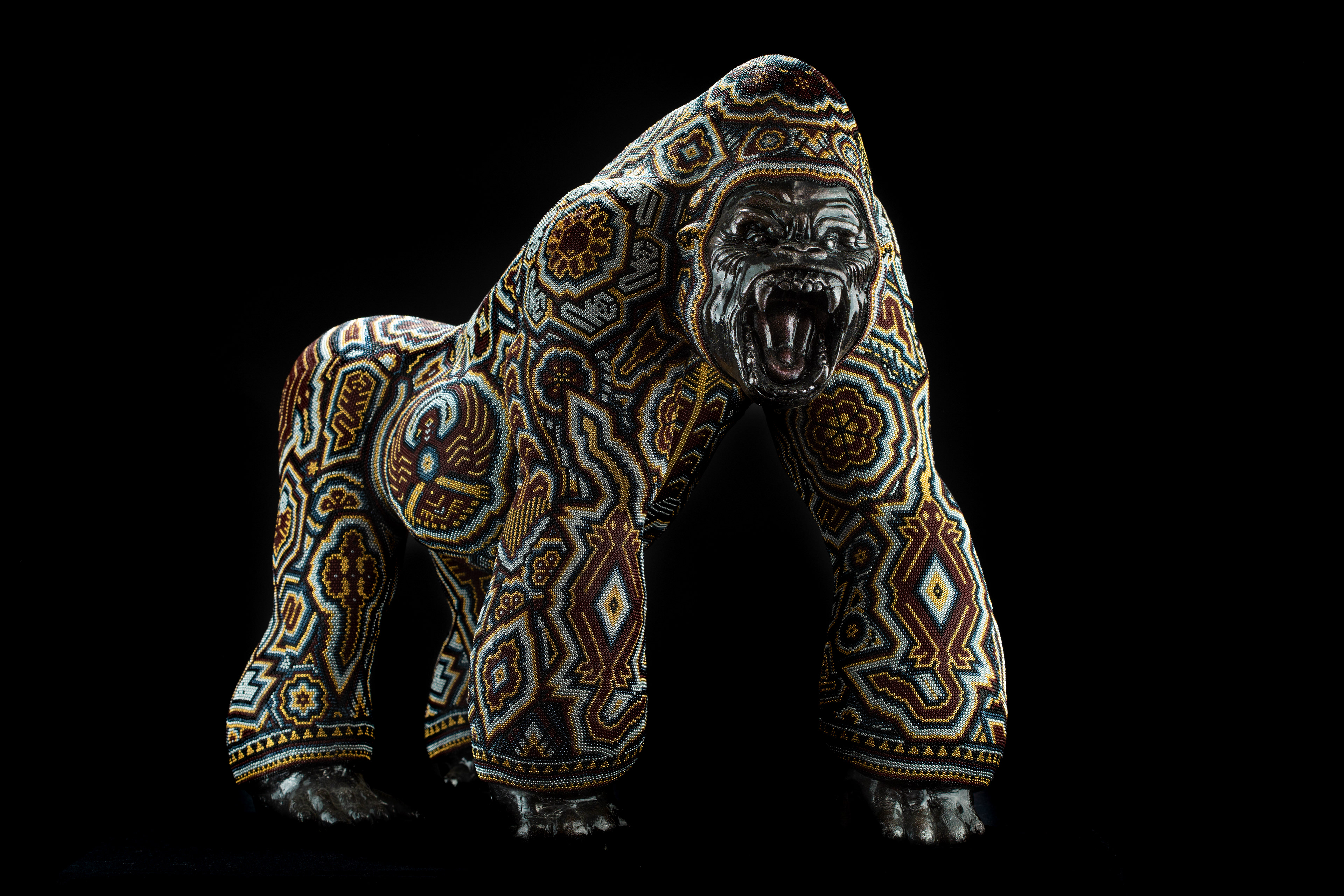 Beaded gorilla sculpture against a black background