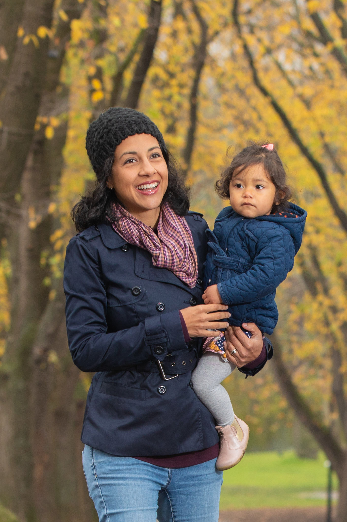 Parent holding a child under golden autumn trees