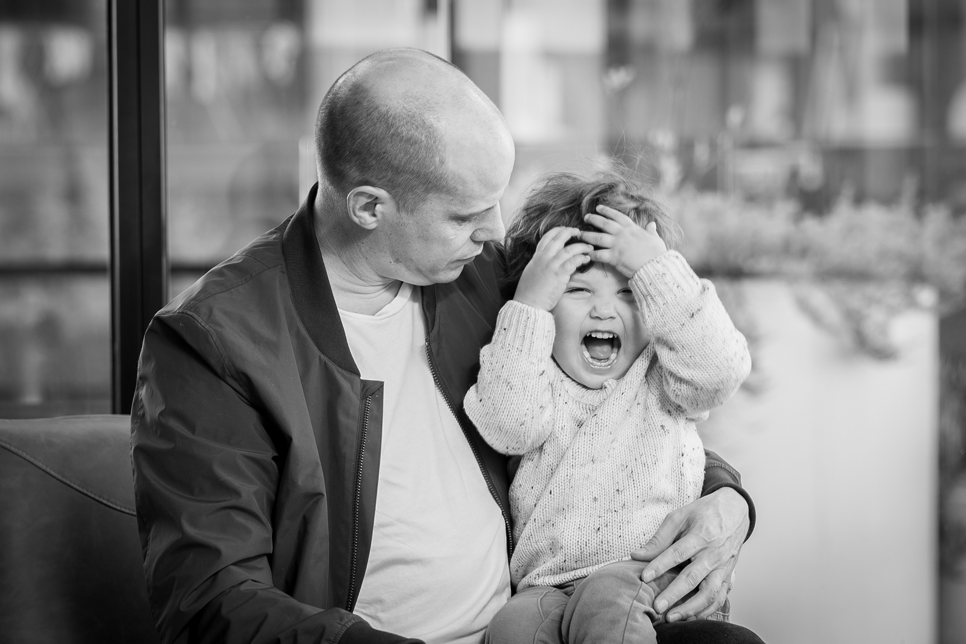 Black-and-white close-up of a parent cradling a baby