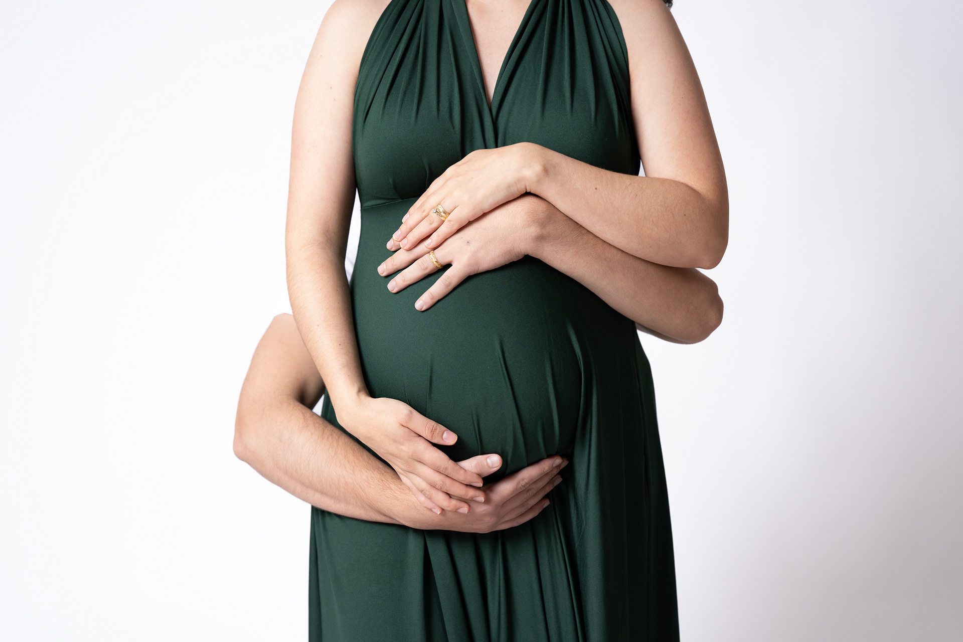 Close-up maternity portrait in a dark green dress