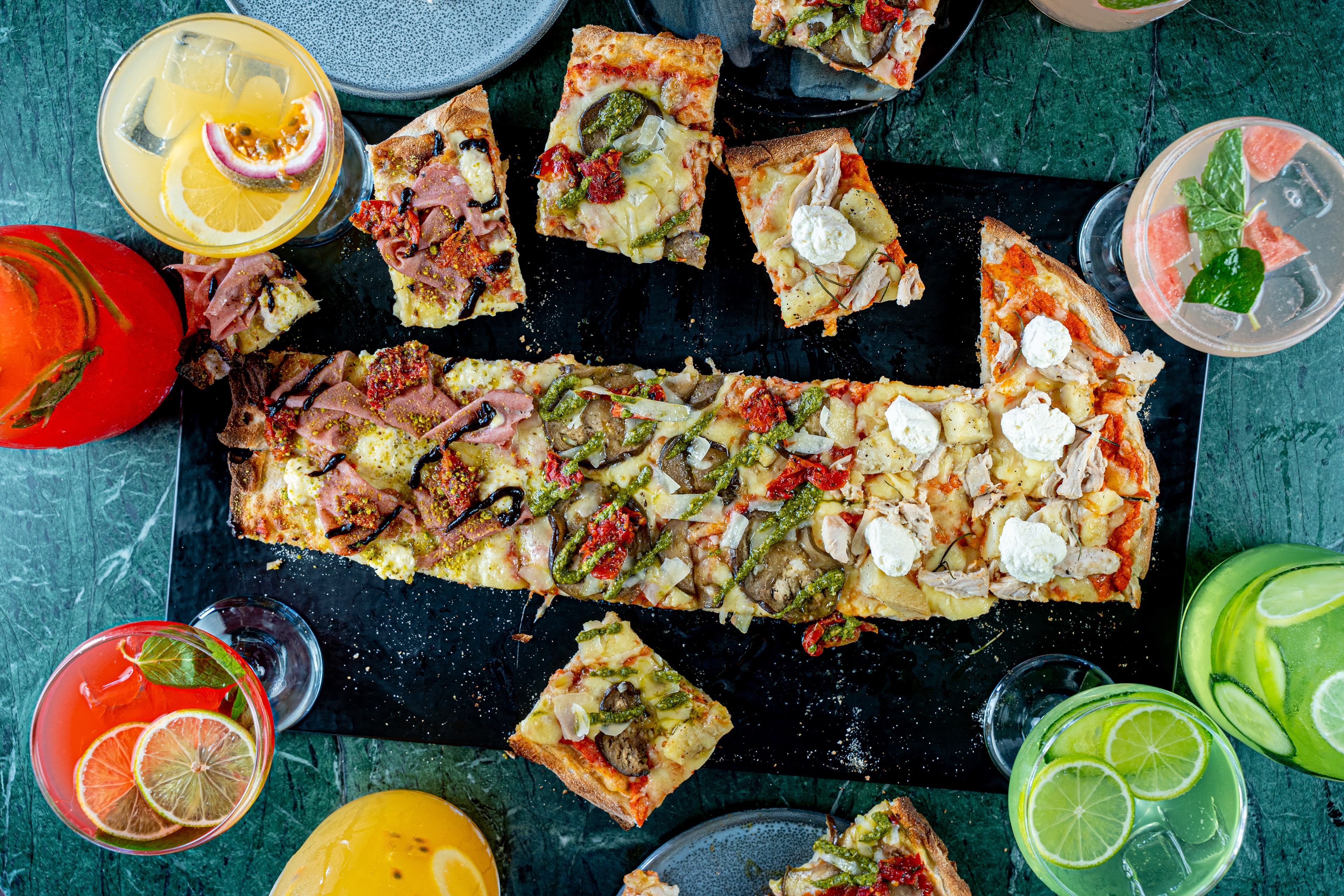 Overhead view of topped flatbreads and dipping sauces