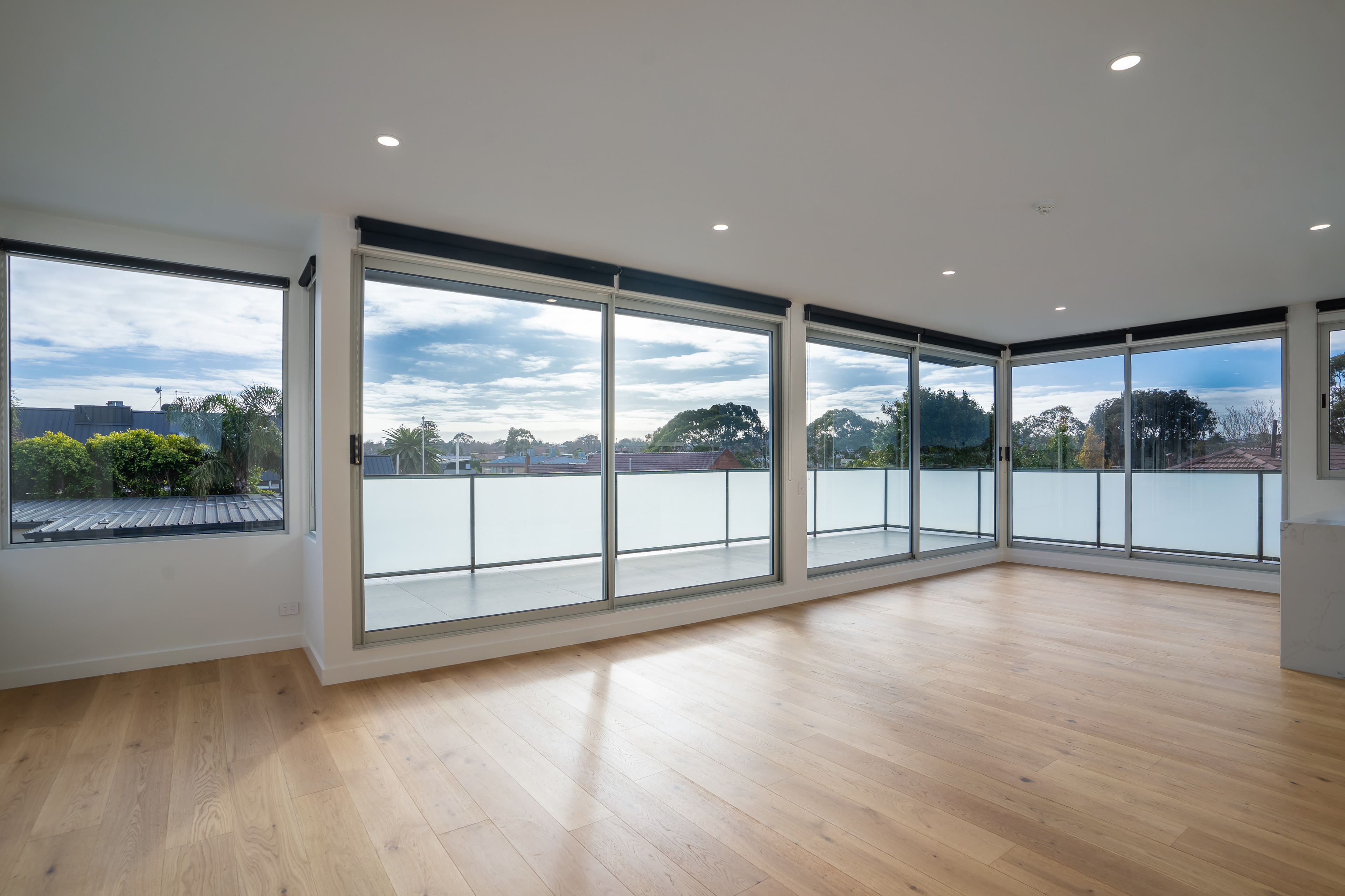 Wide view of a bright living area with wraparound windows