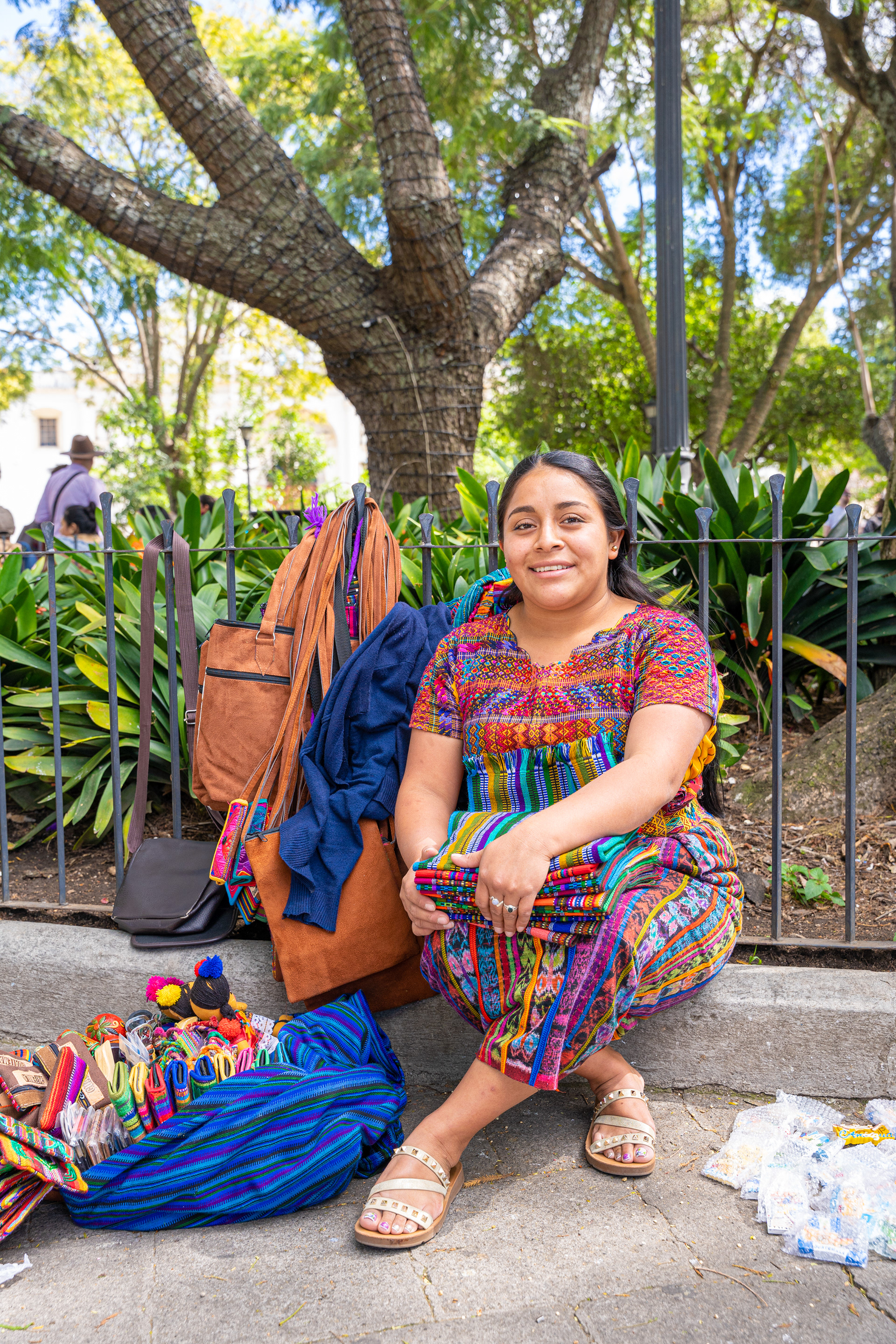 Two people seated beneath a tree in colourful clothing