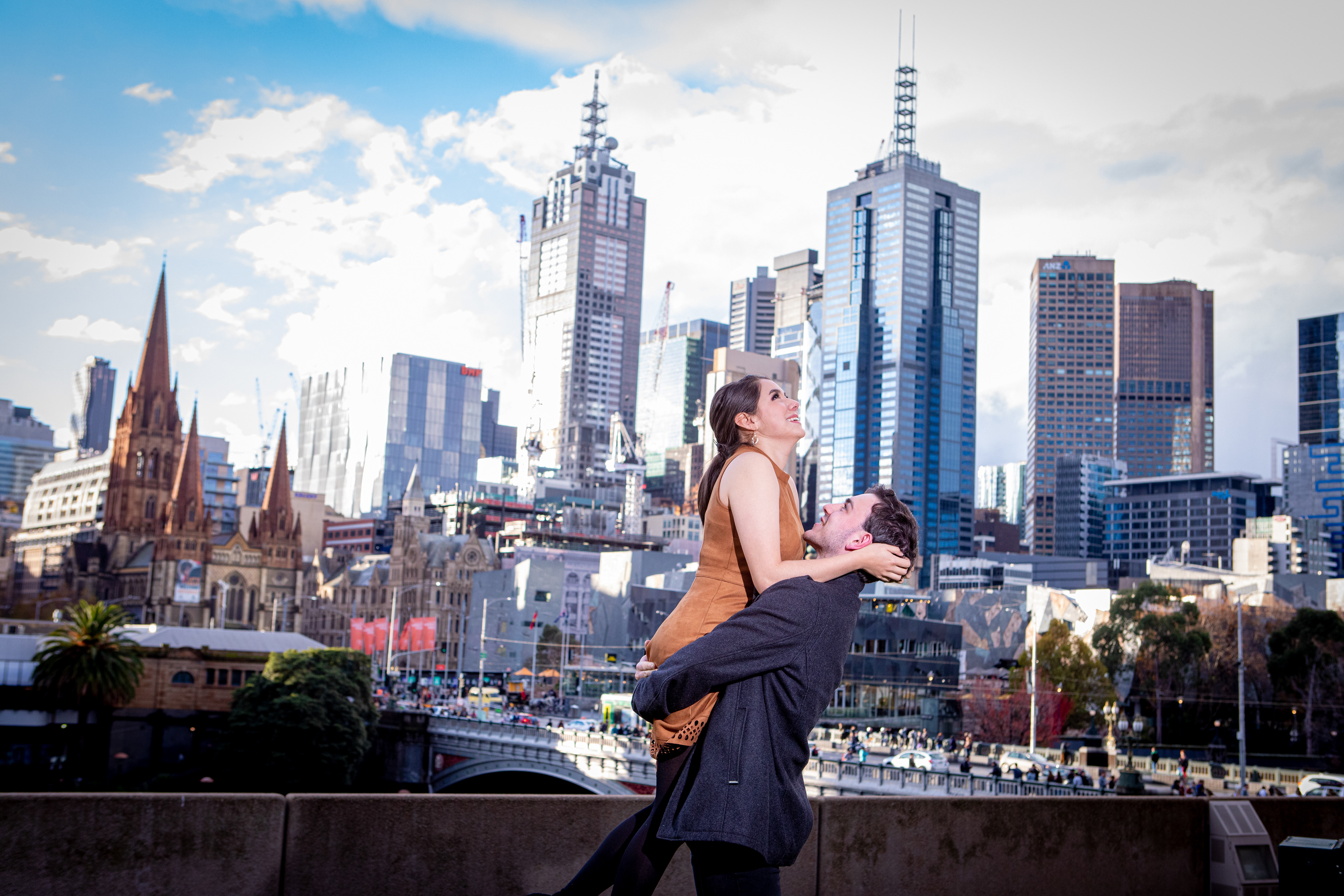 Couple beside the river with the Melbourne skyline behind