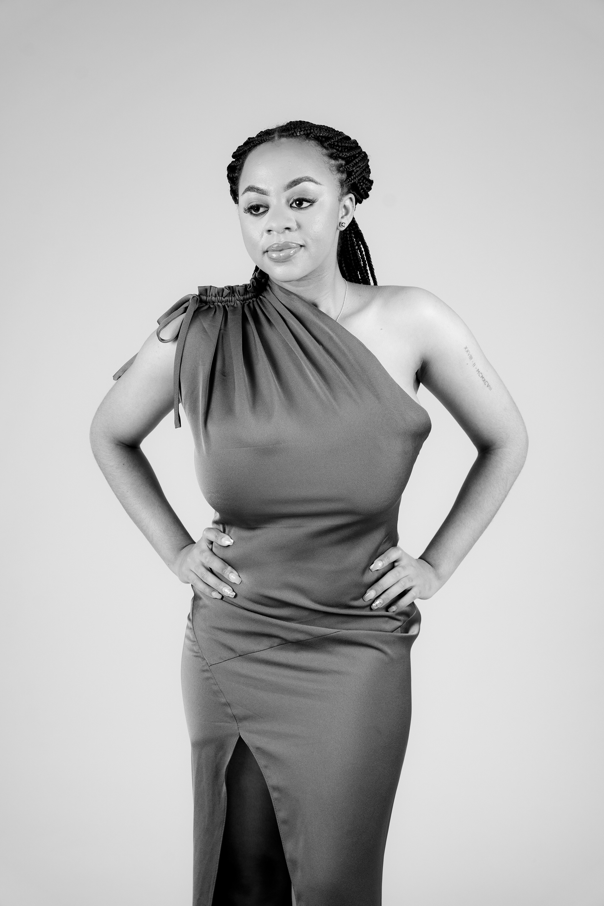 Black-and-white studio portrait in a fitted dress