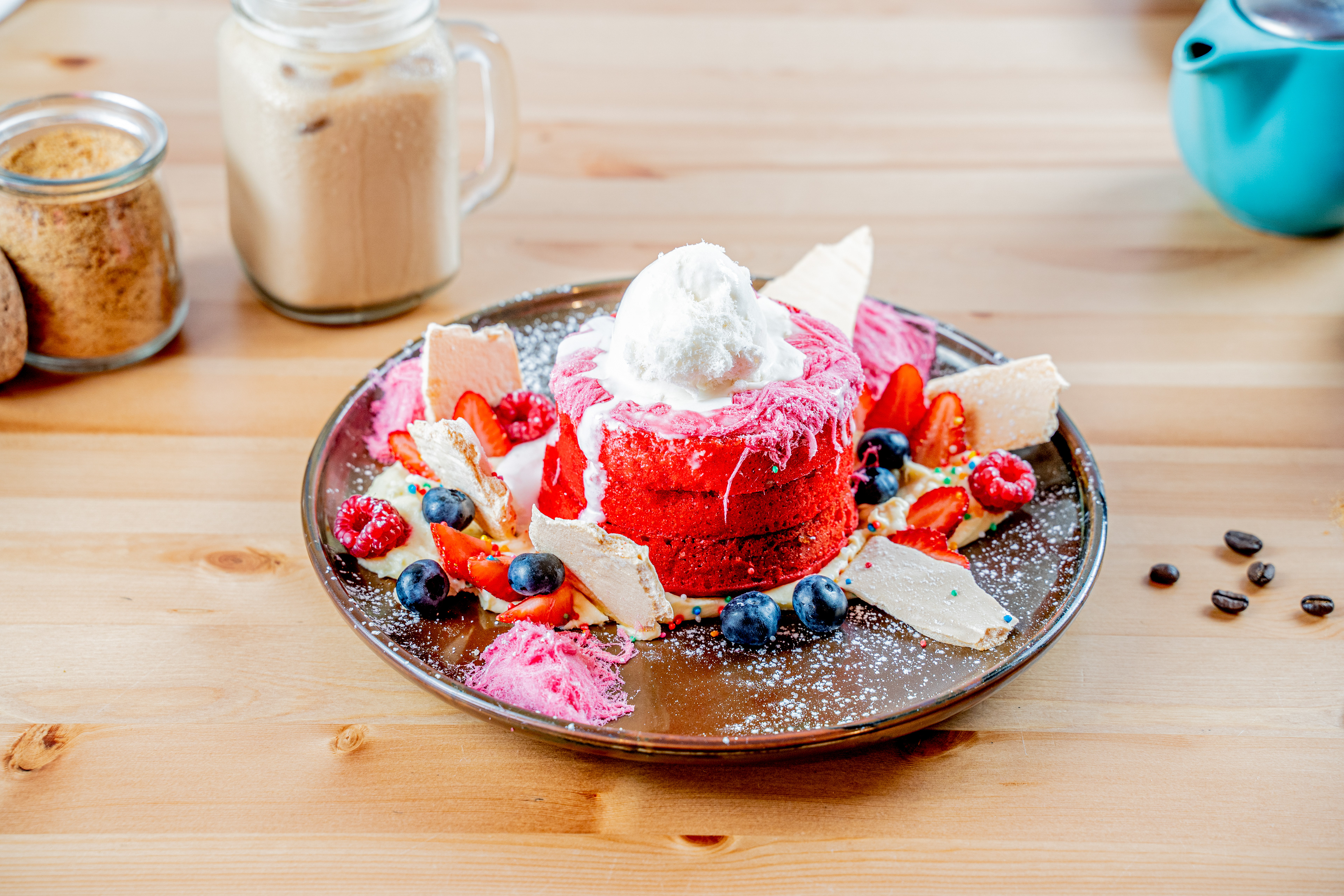 Pink dessert topped with berries and meringue on a cafe table