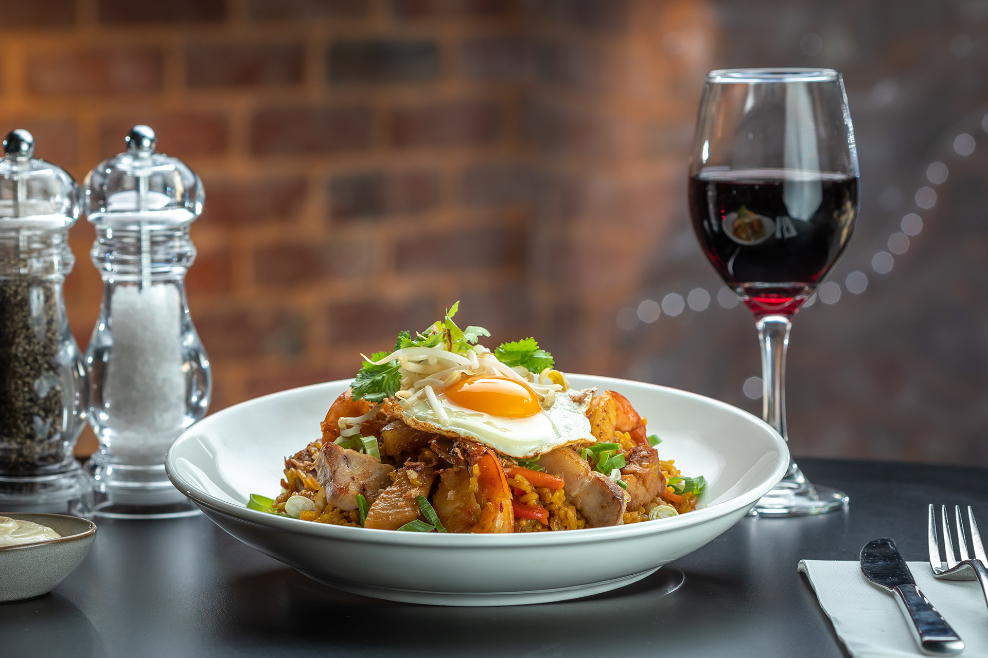 Plated pasta beside a glass of red wine