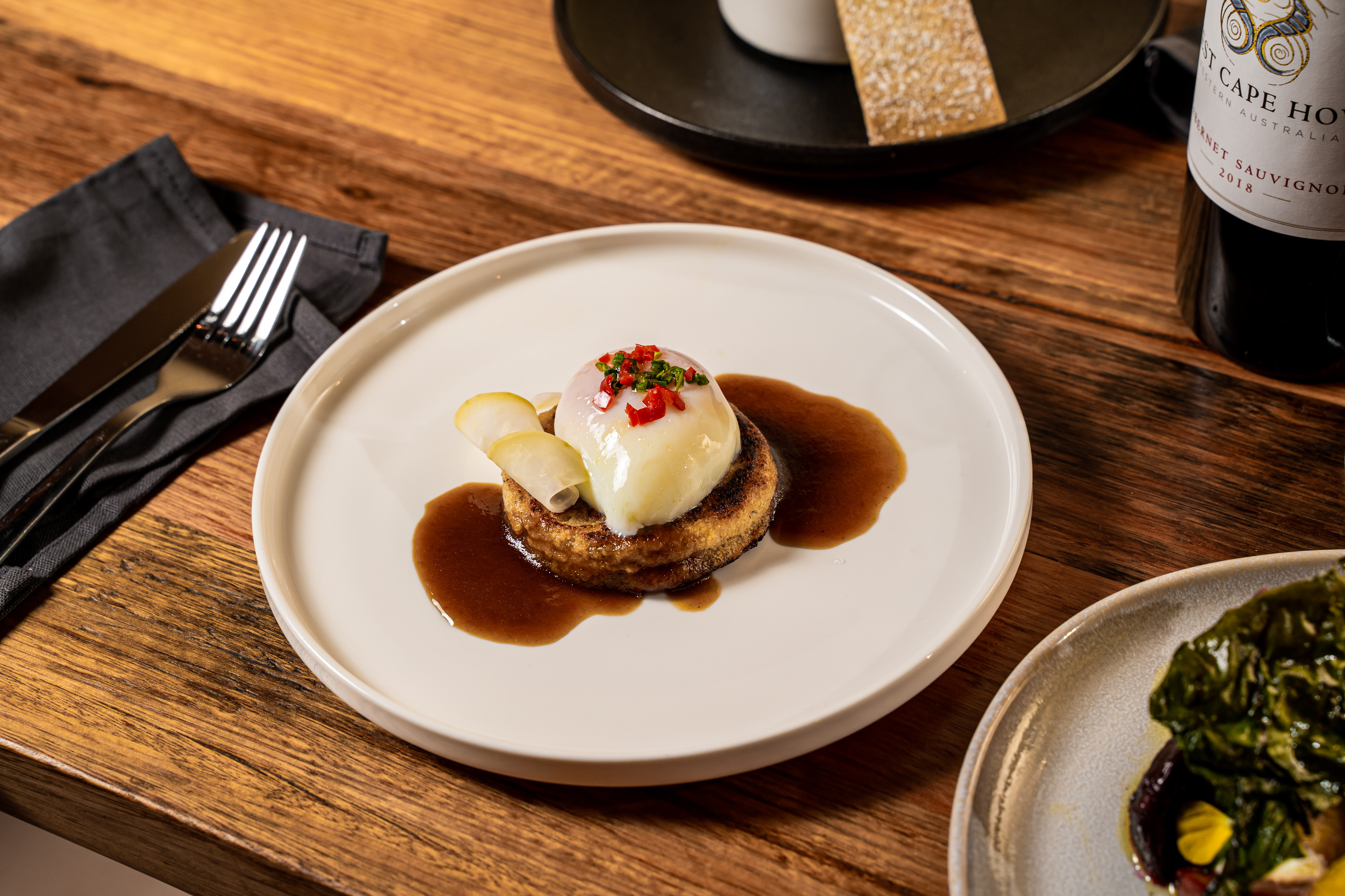 Plated dessert topped with berries on a wooden table