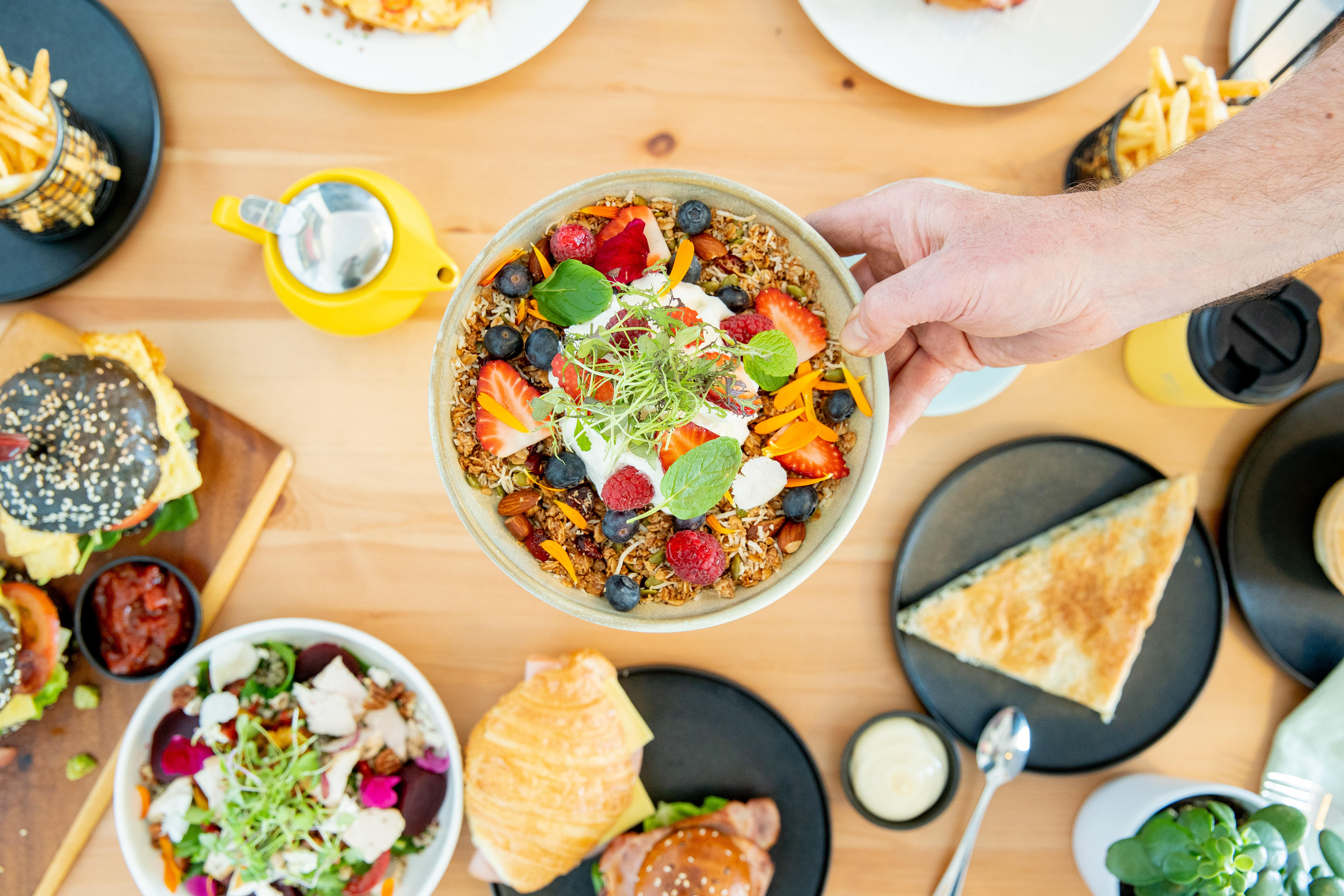 Overhead view of colourful brunch dishes on a cafe table