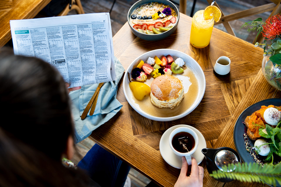 Overhead view of breakfast dishes, drinks and a menu