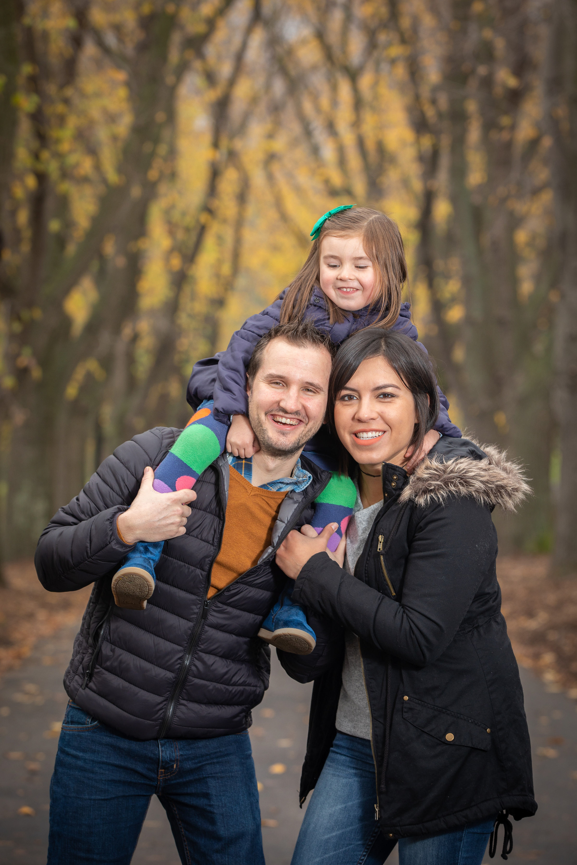 Child riding on a parent’s shoulders during an autumn walk
