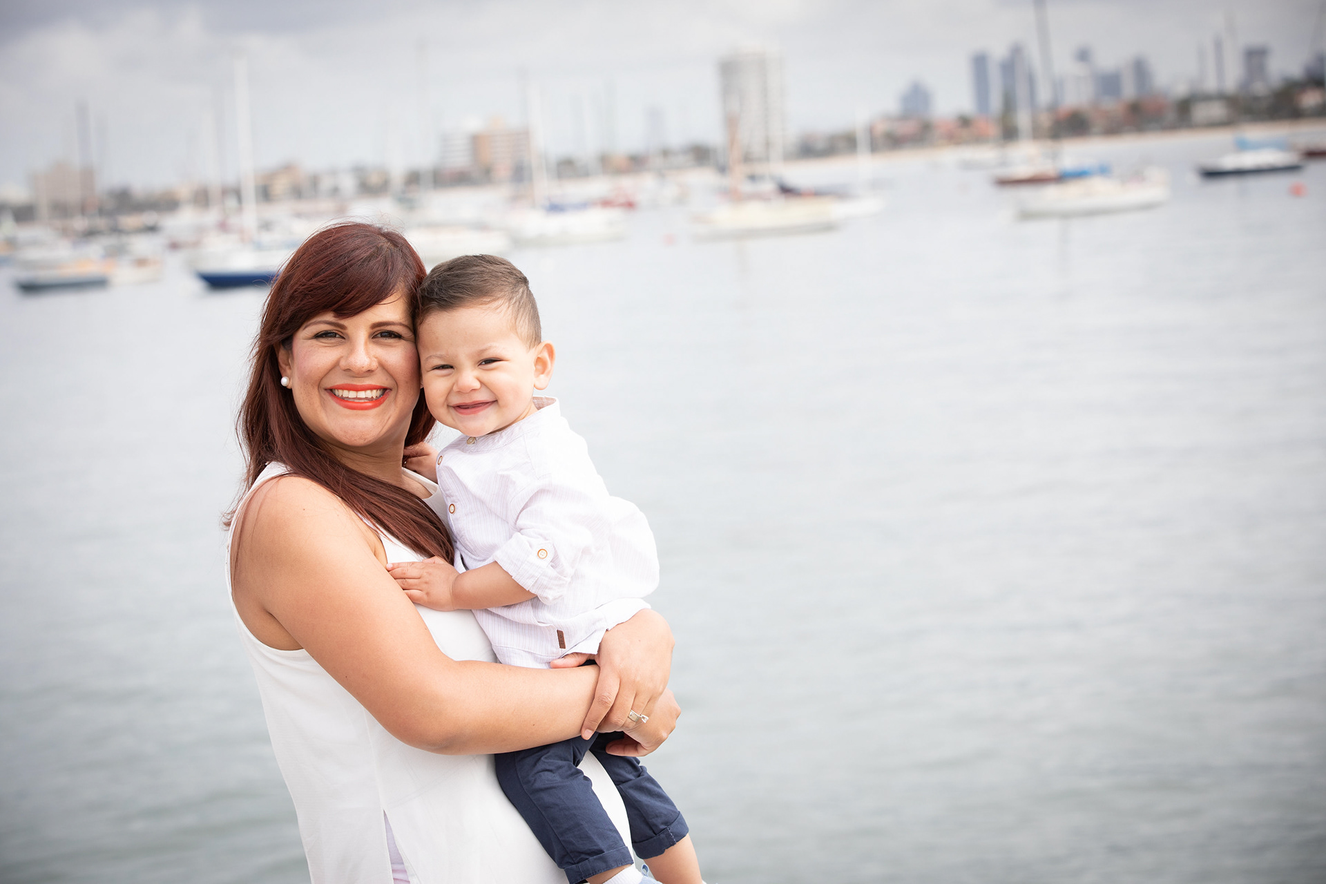 Baby held beside a waterfront view