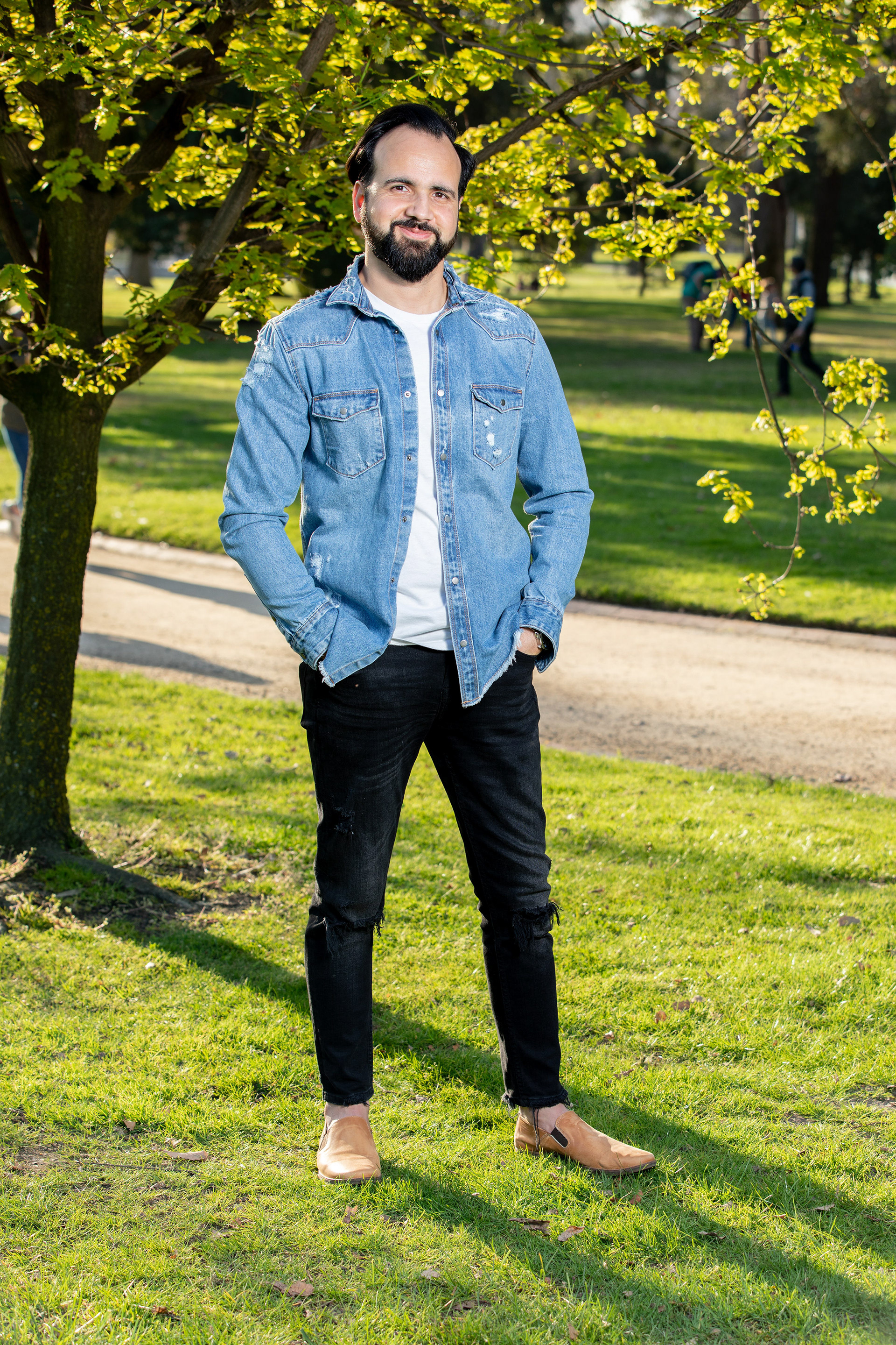 Full-length outdoor portrait in a blue blazer among trees