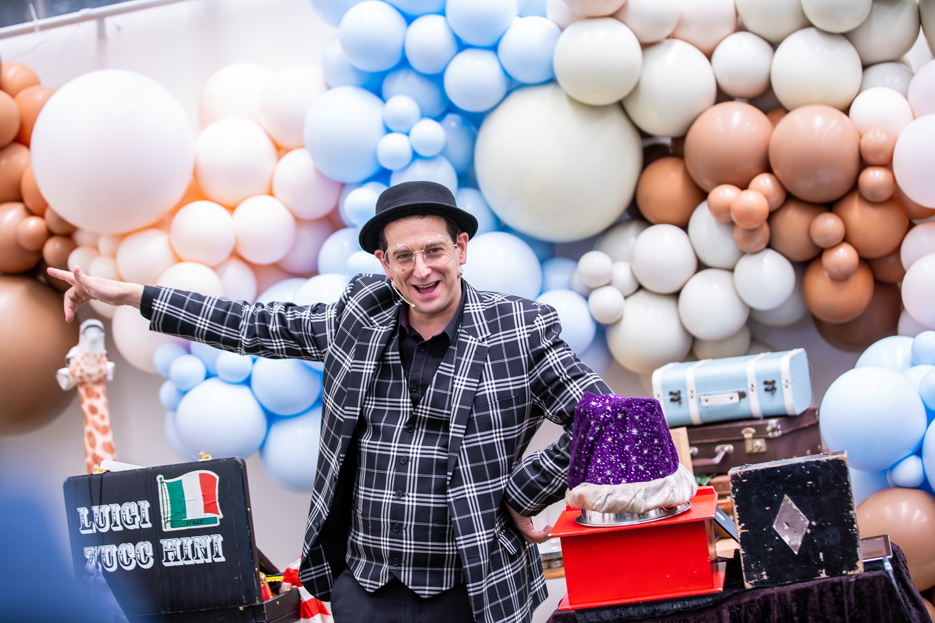 Party performer posing in front of a balloon display