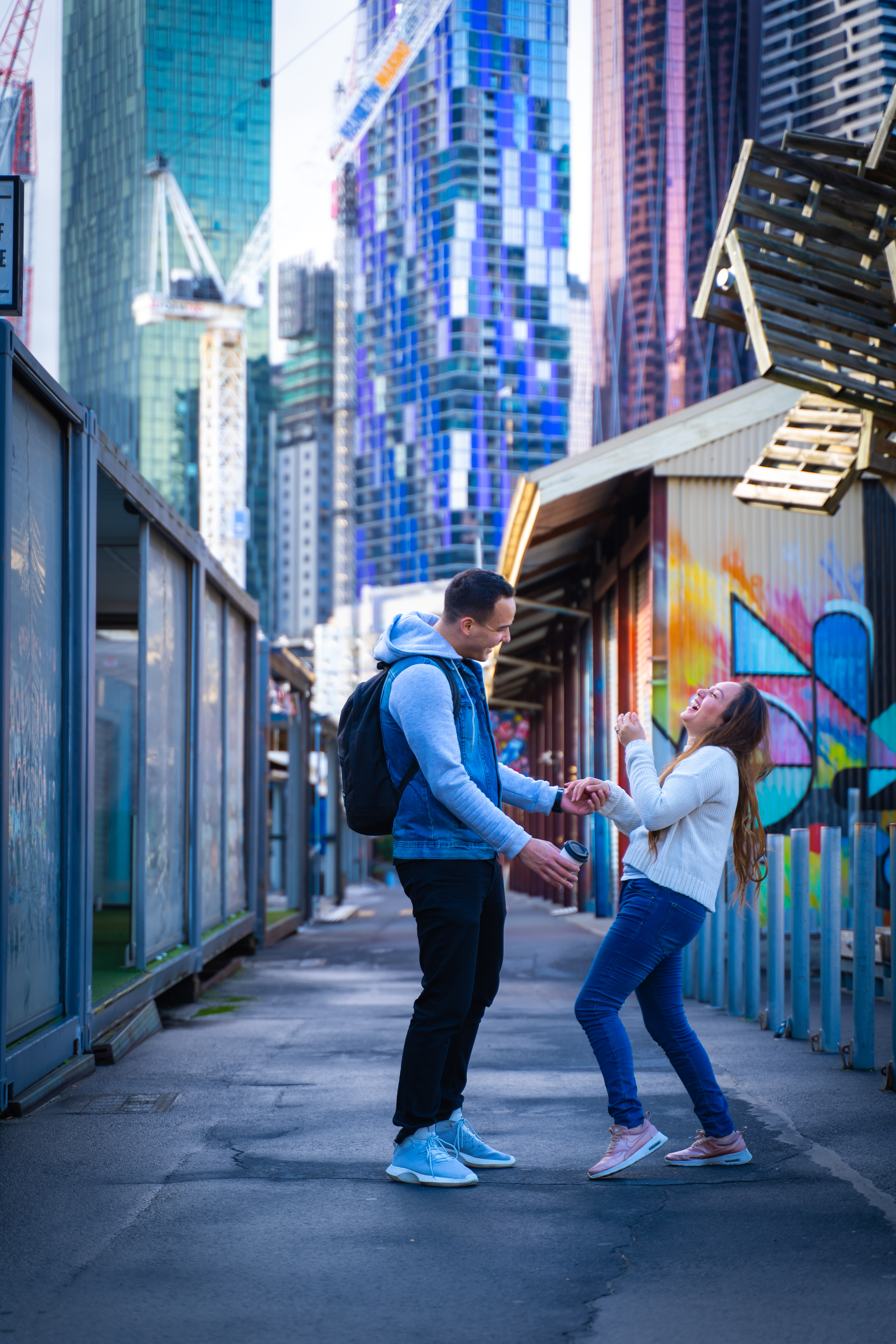 Couple posing in a colourful street-art laneway