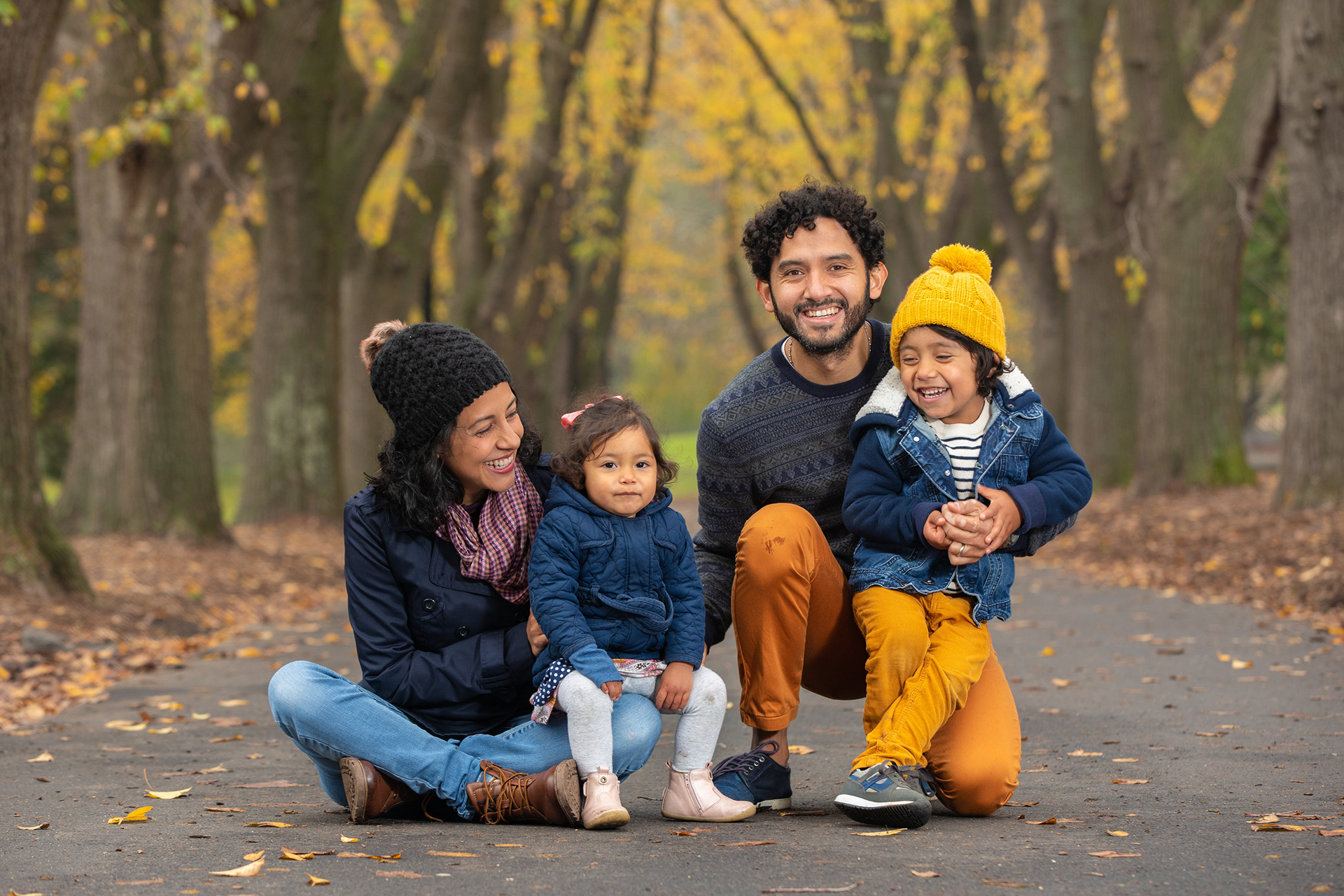 Parent and child sitting together beneath autumn trees