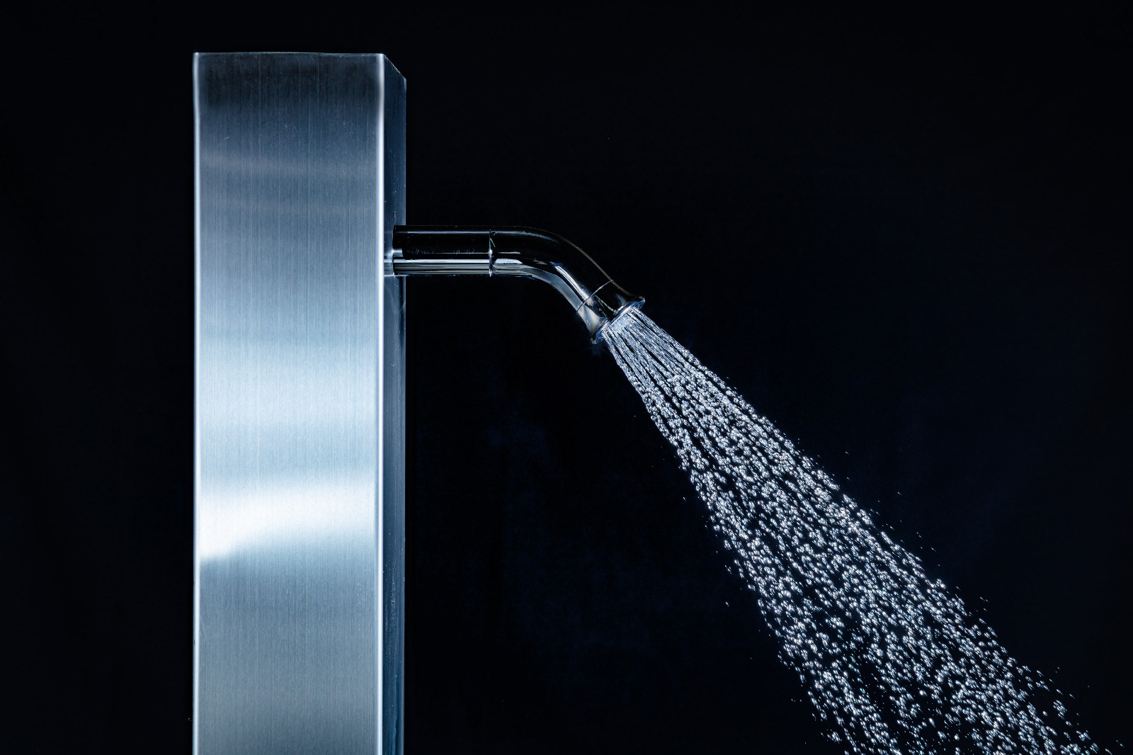 Shower panel spraying water against a dark background