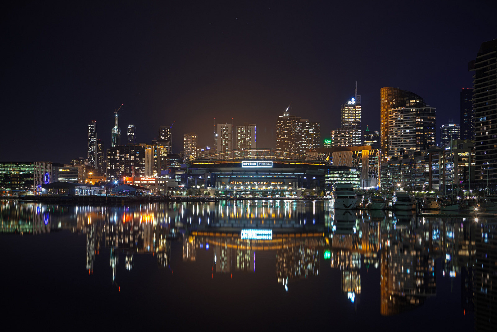 City skyline reflected in dark water at night