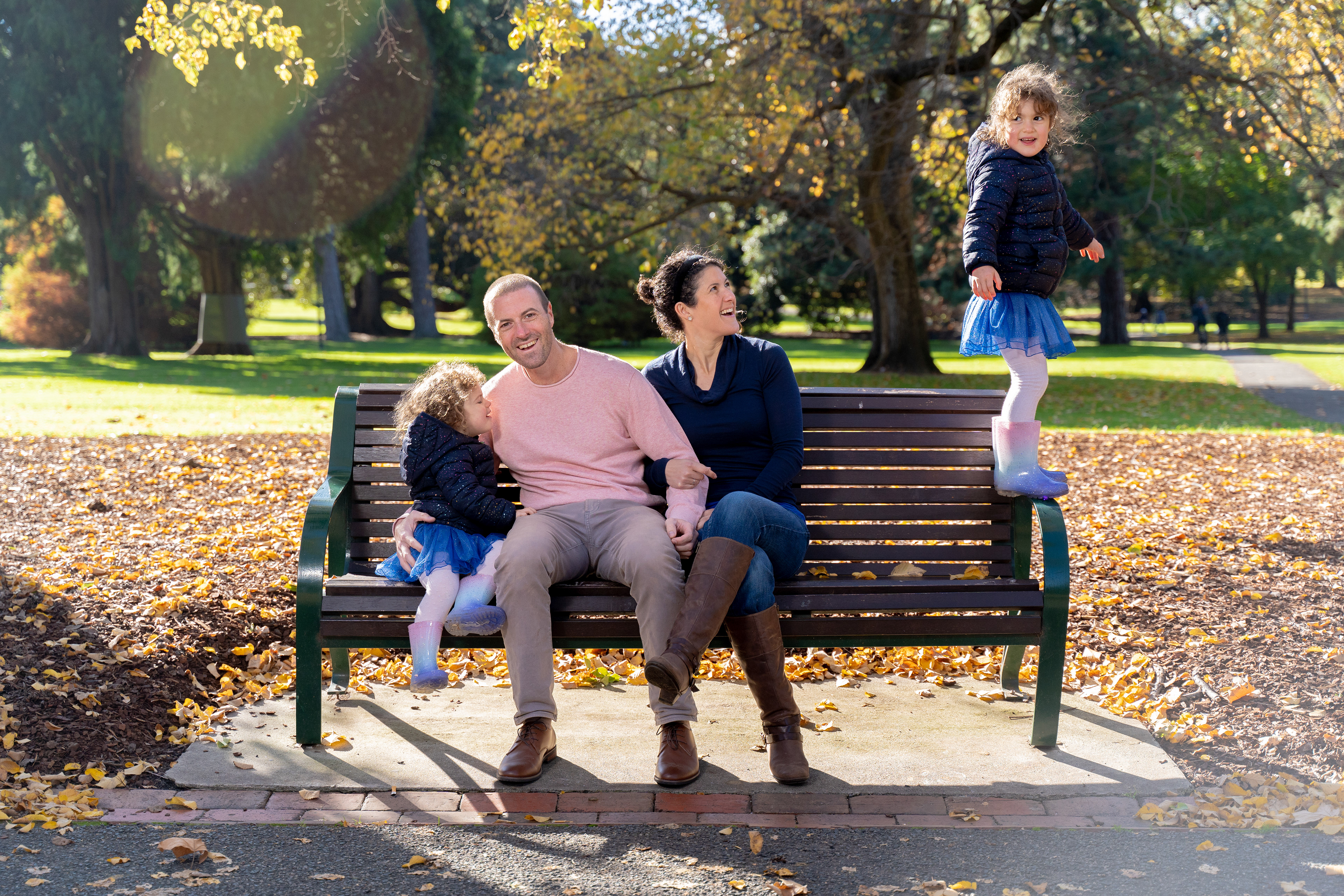Family relaxing together on a park bench
