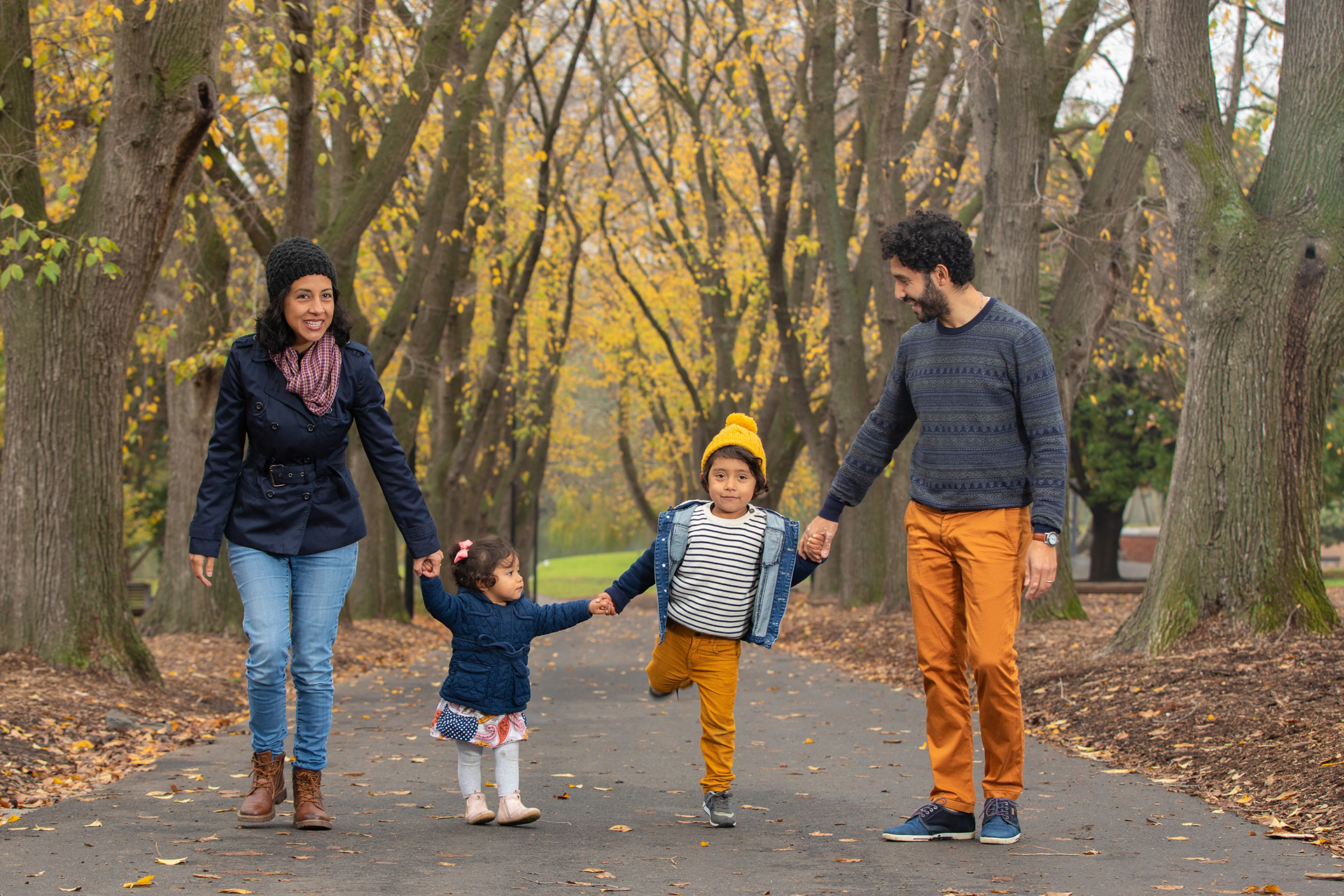 Family holding hands while walking along a park path