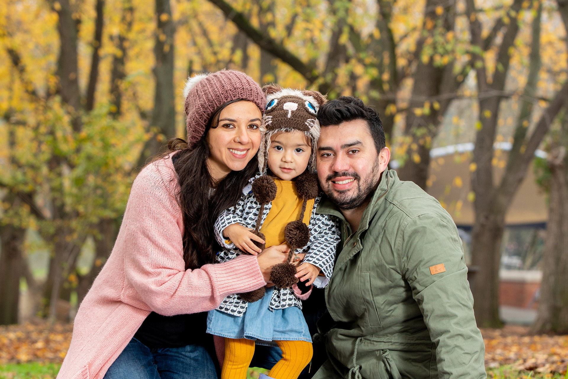 Close-up family portrait beneath autumn foliage