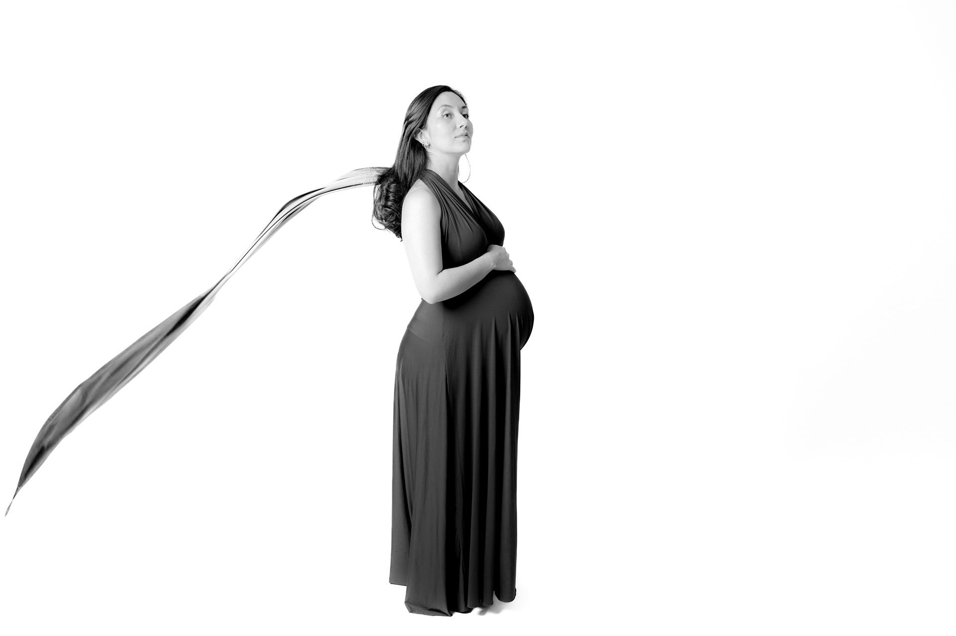 Black-and-white maternity portrait with flowing fabric