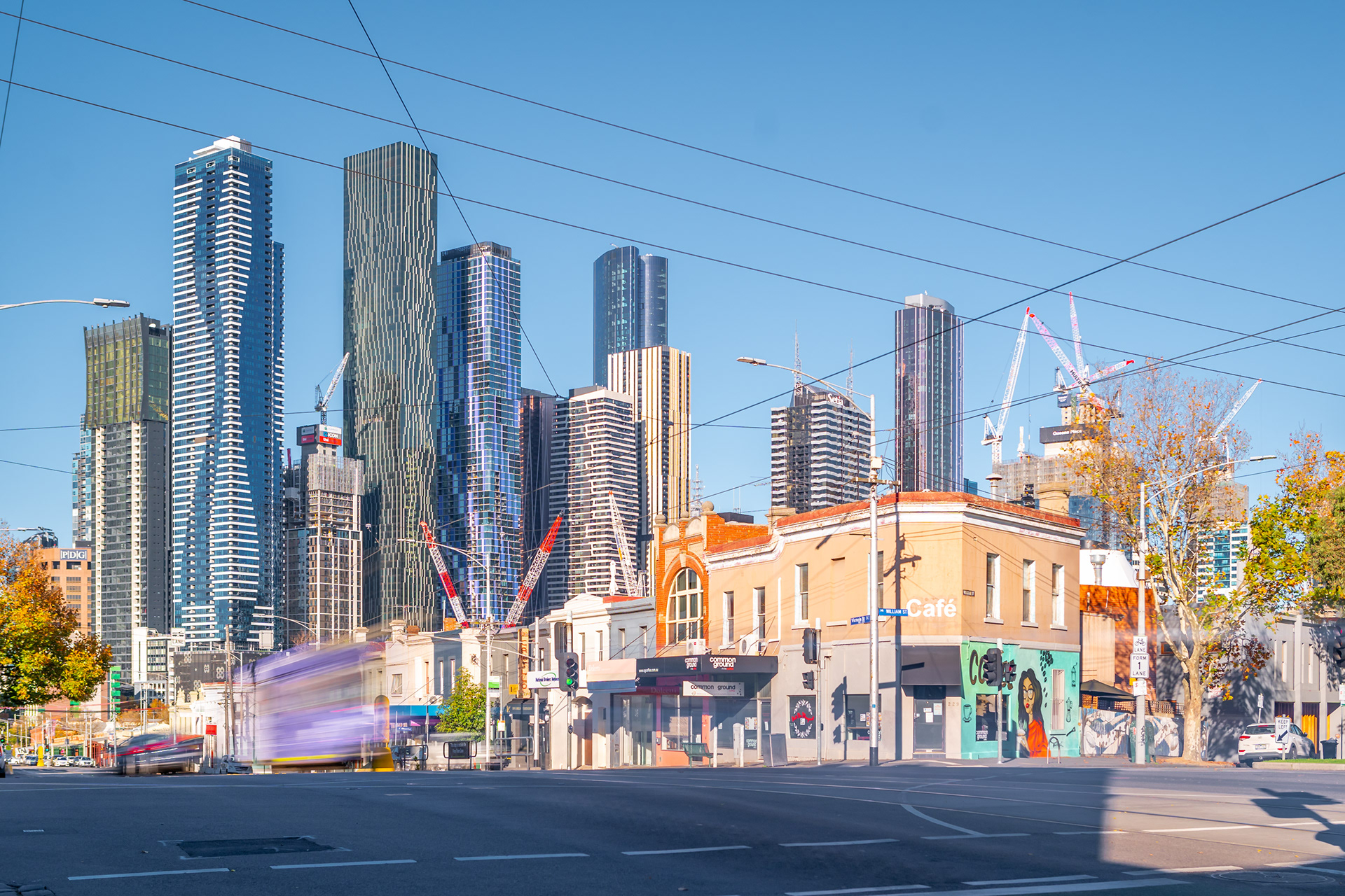 Melbourne skyline and a passing tram above a city intersection