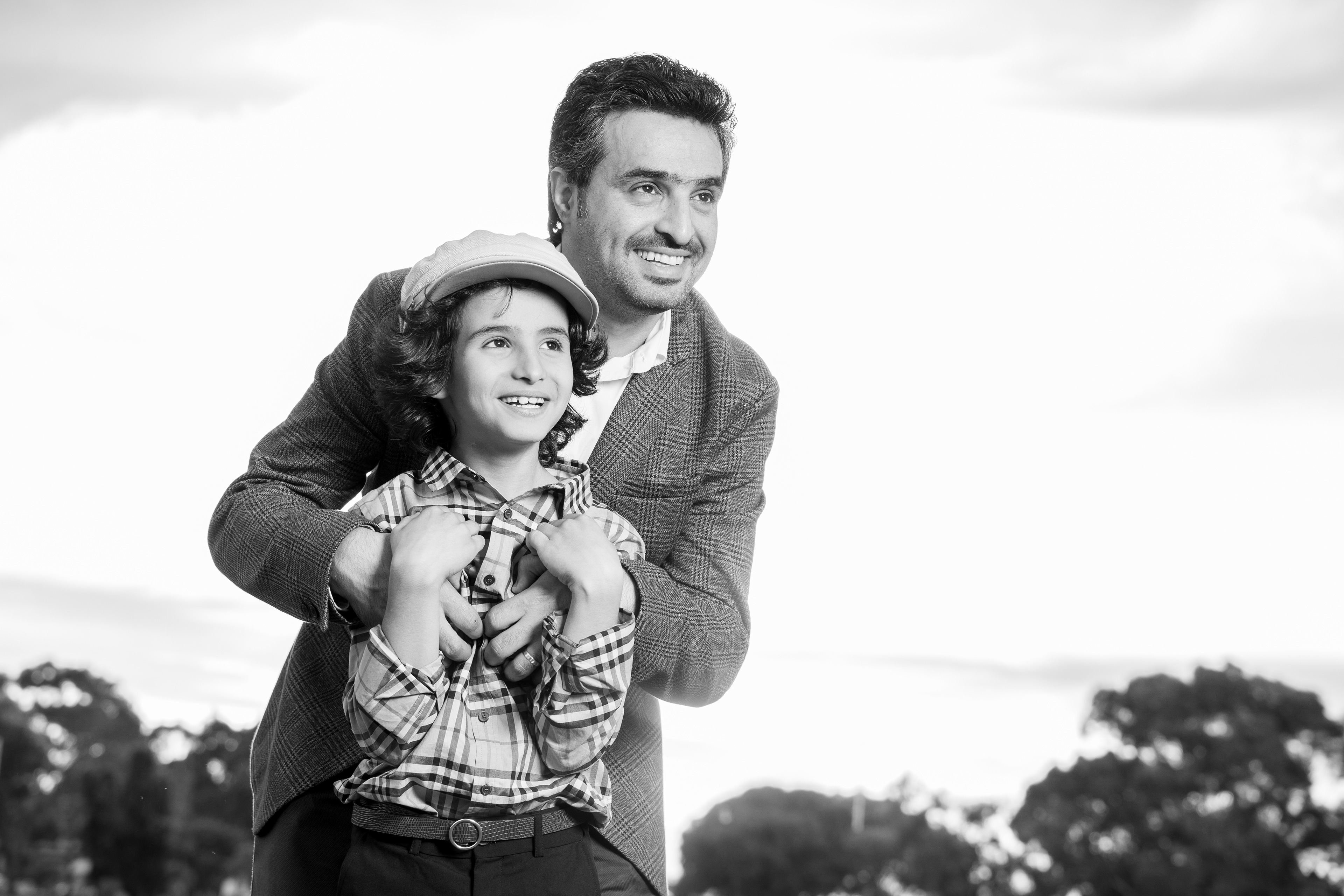 Black-and-white portrait of a child on a parent’s shoulders