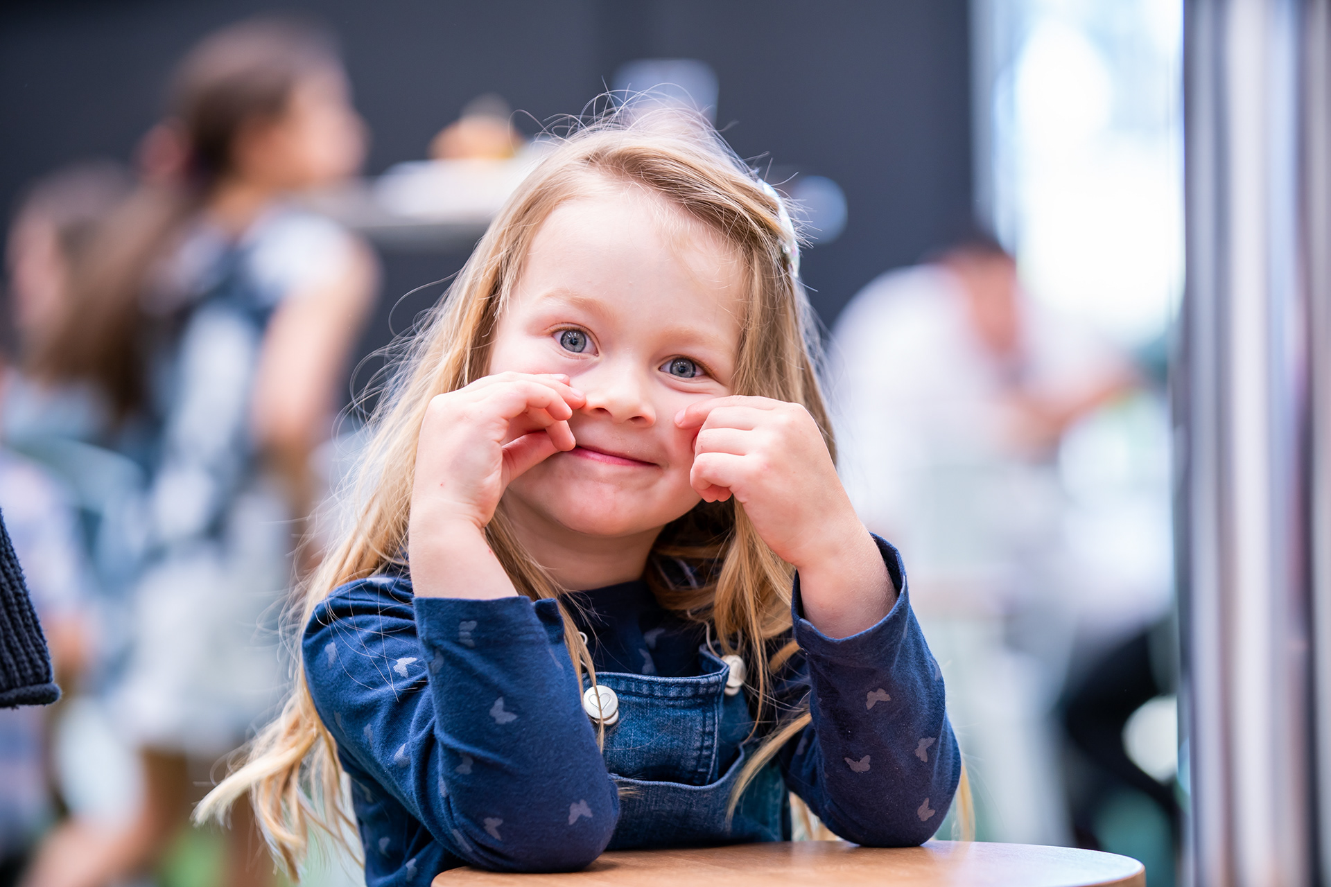 Smiling child resting their chin on folded arms