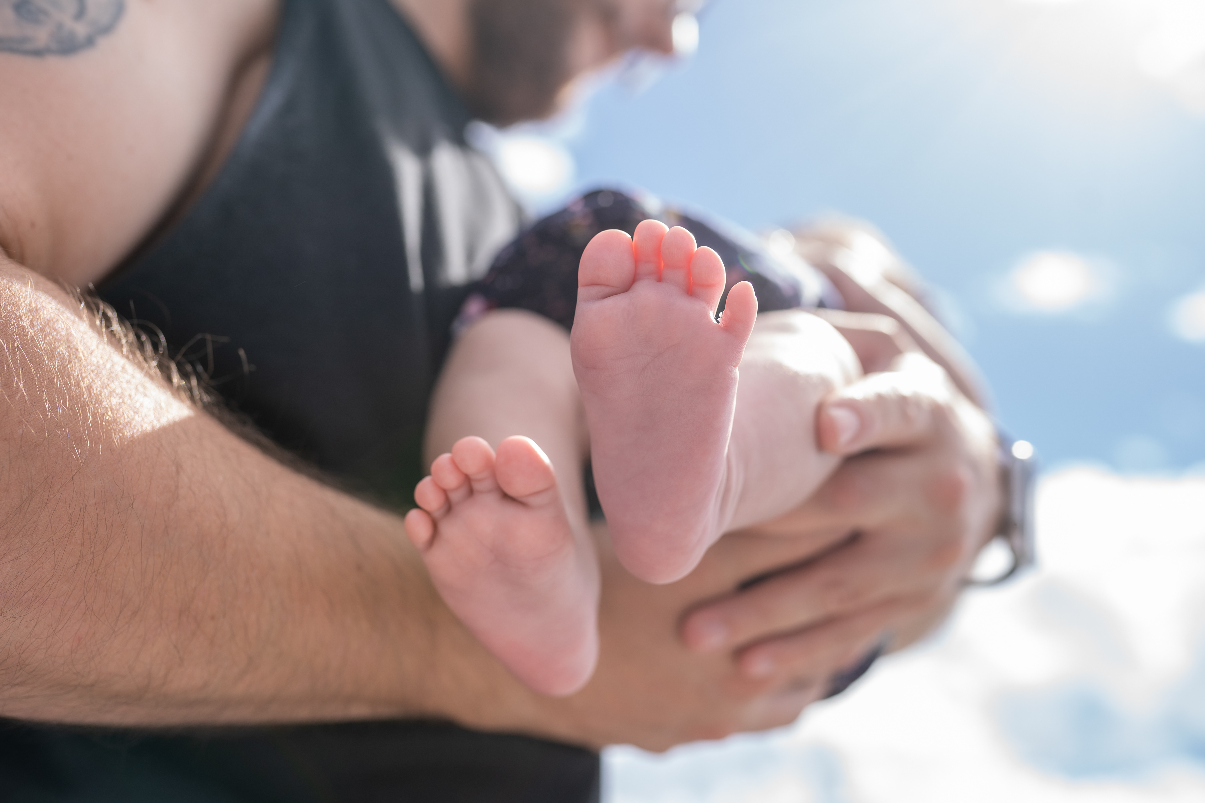 Parent cradling a sleeping newborn in both arms