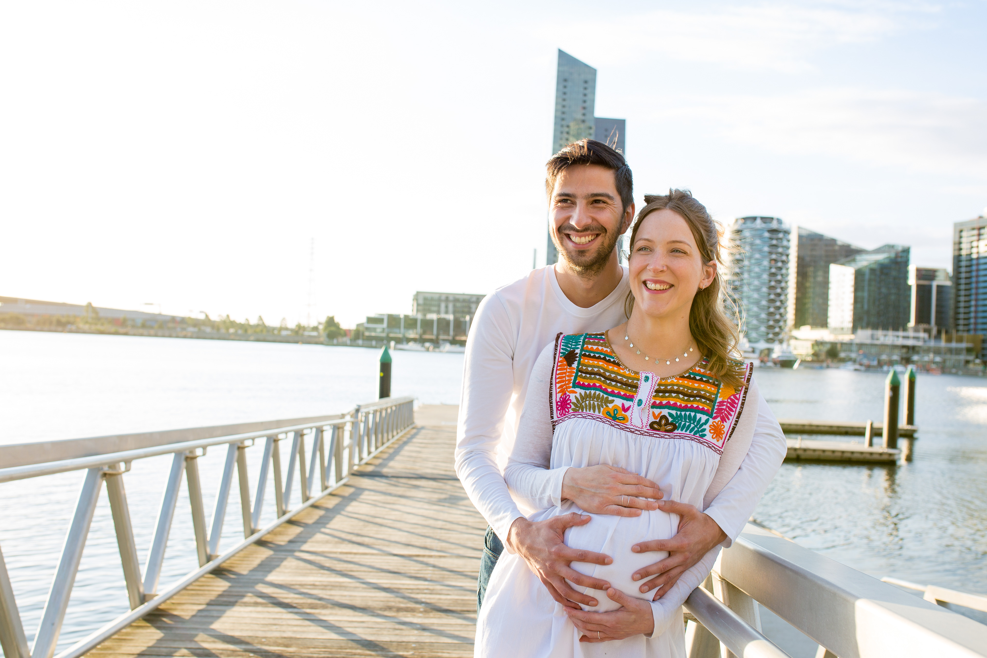 Couple taking a photograph together with the city behind them