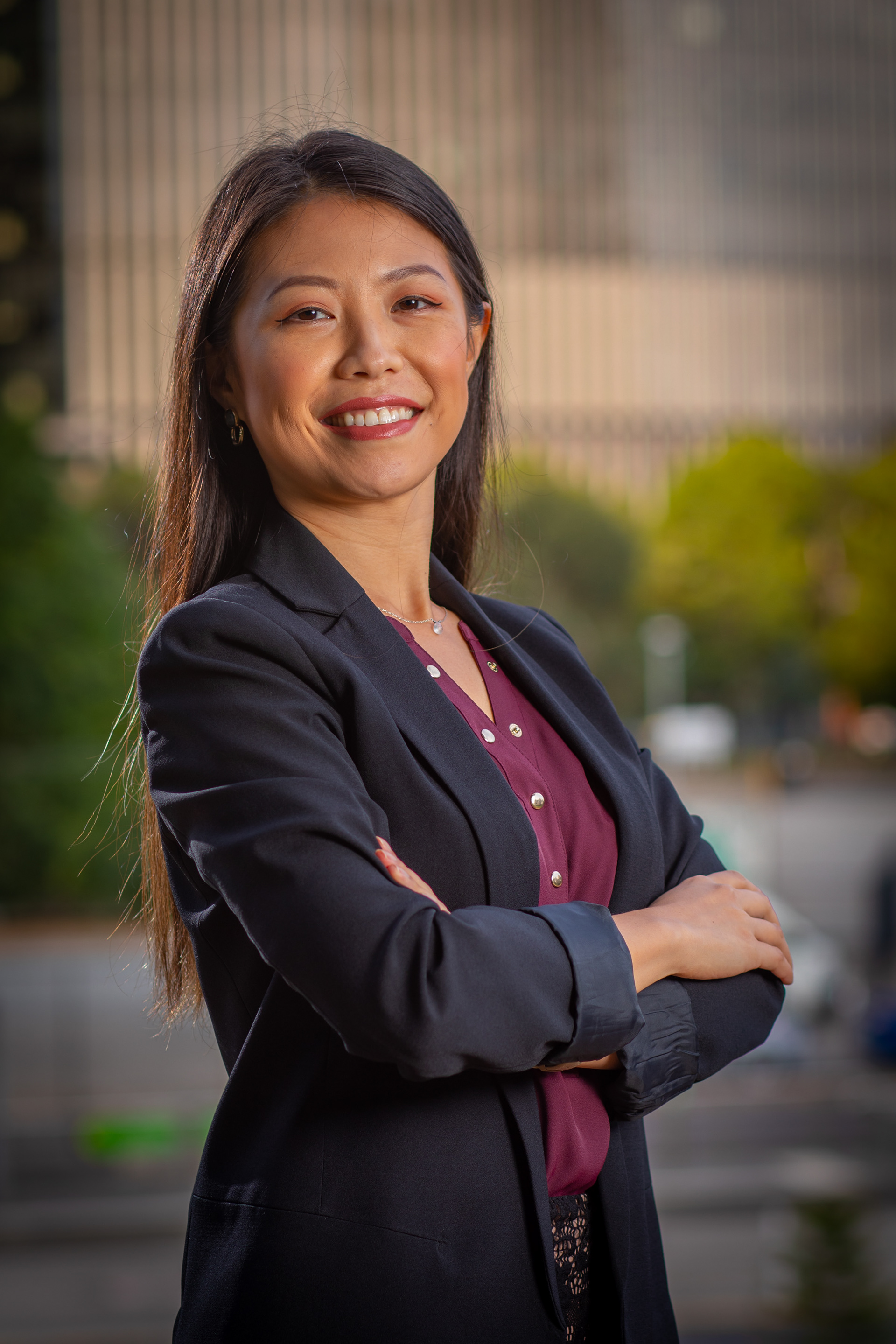 Professional portrait in a dark blazer with arms folded