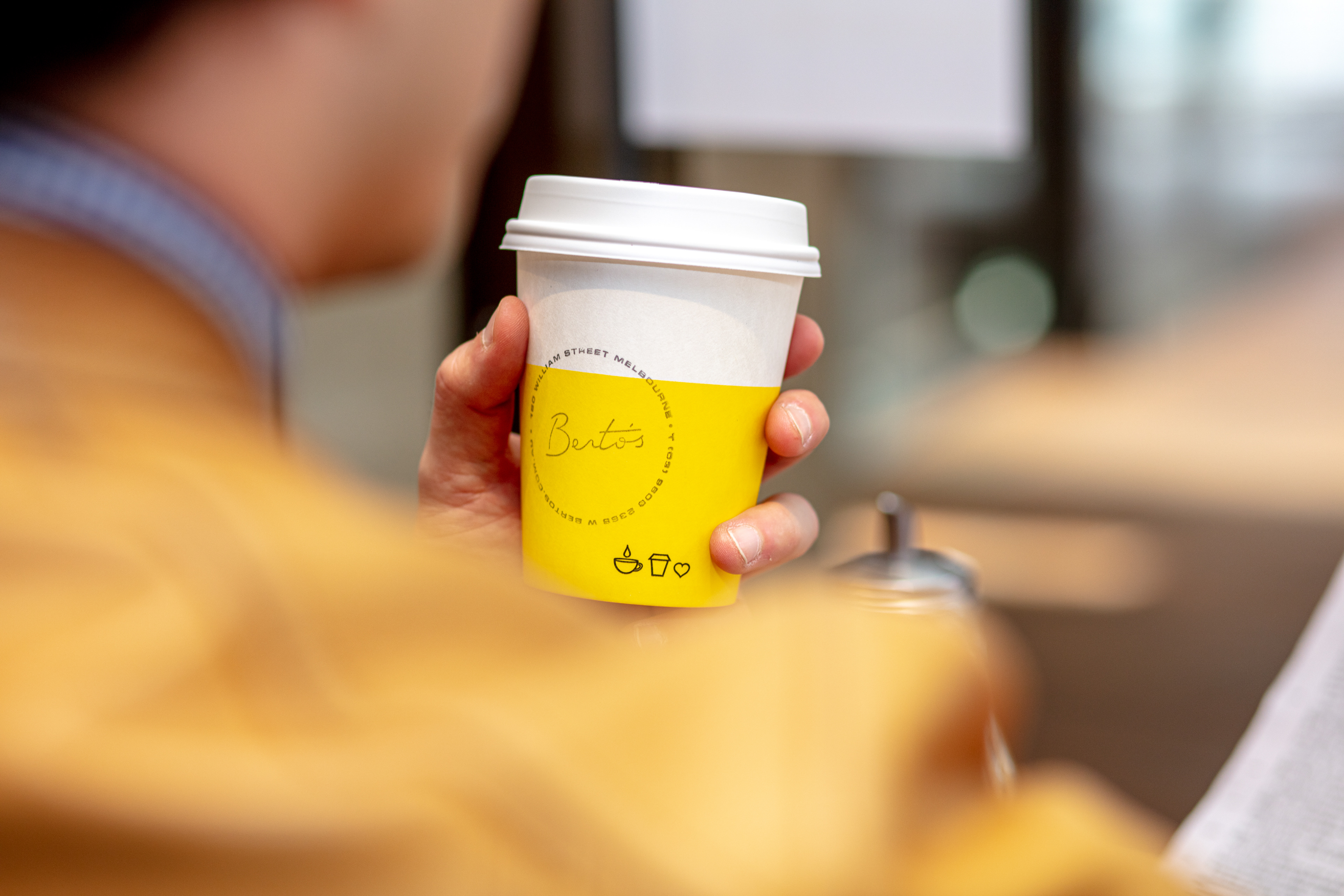 Hand holding a takeaway coffee cup