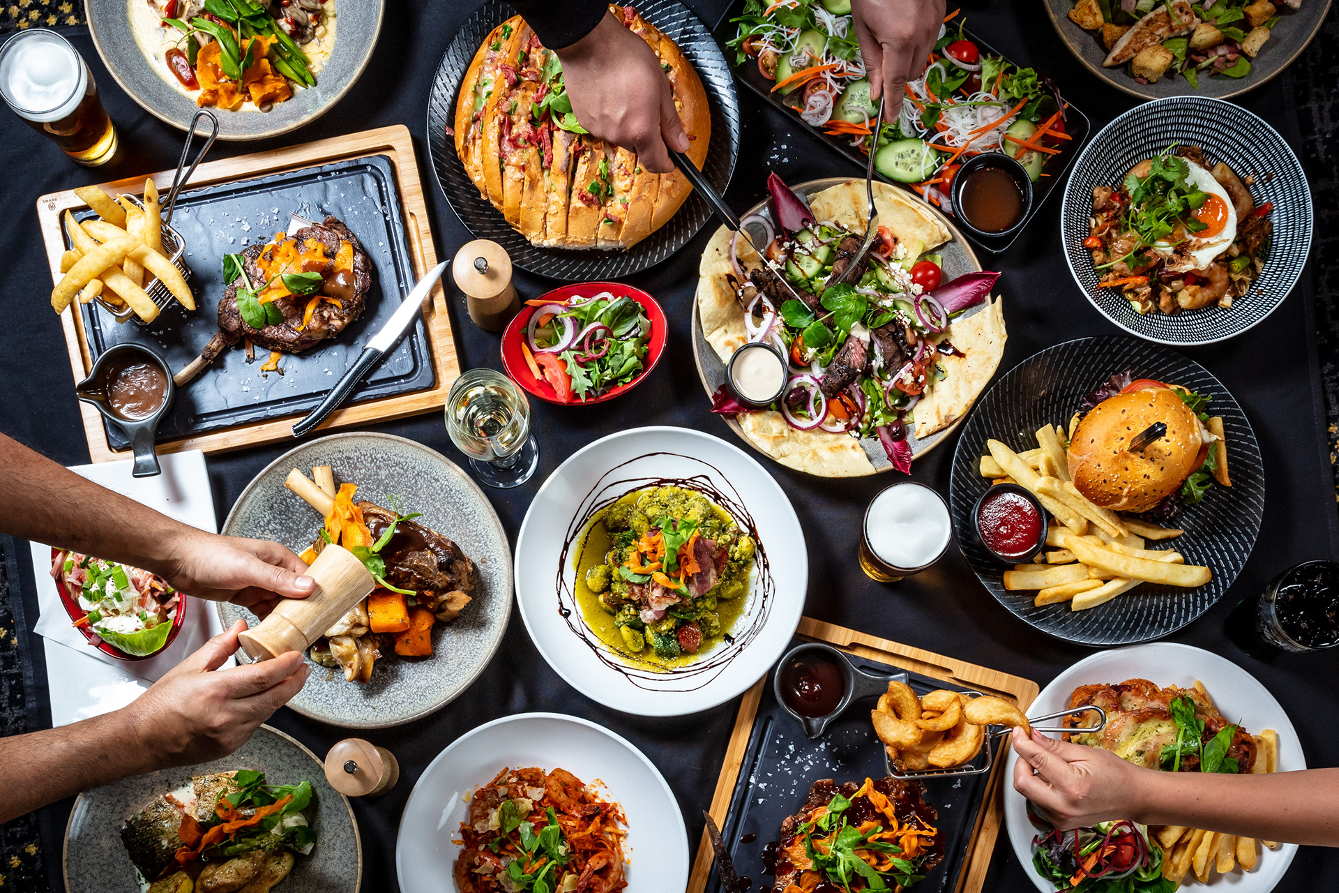 Guests sharing a table filled with restaurant dishes
