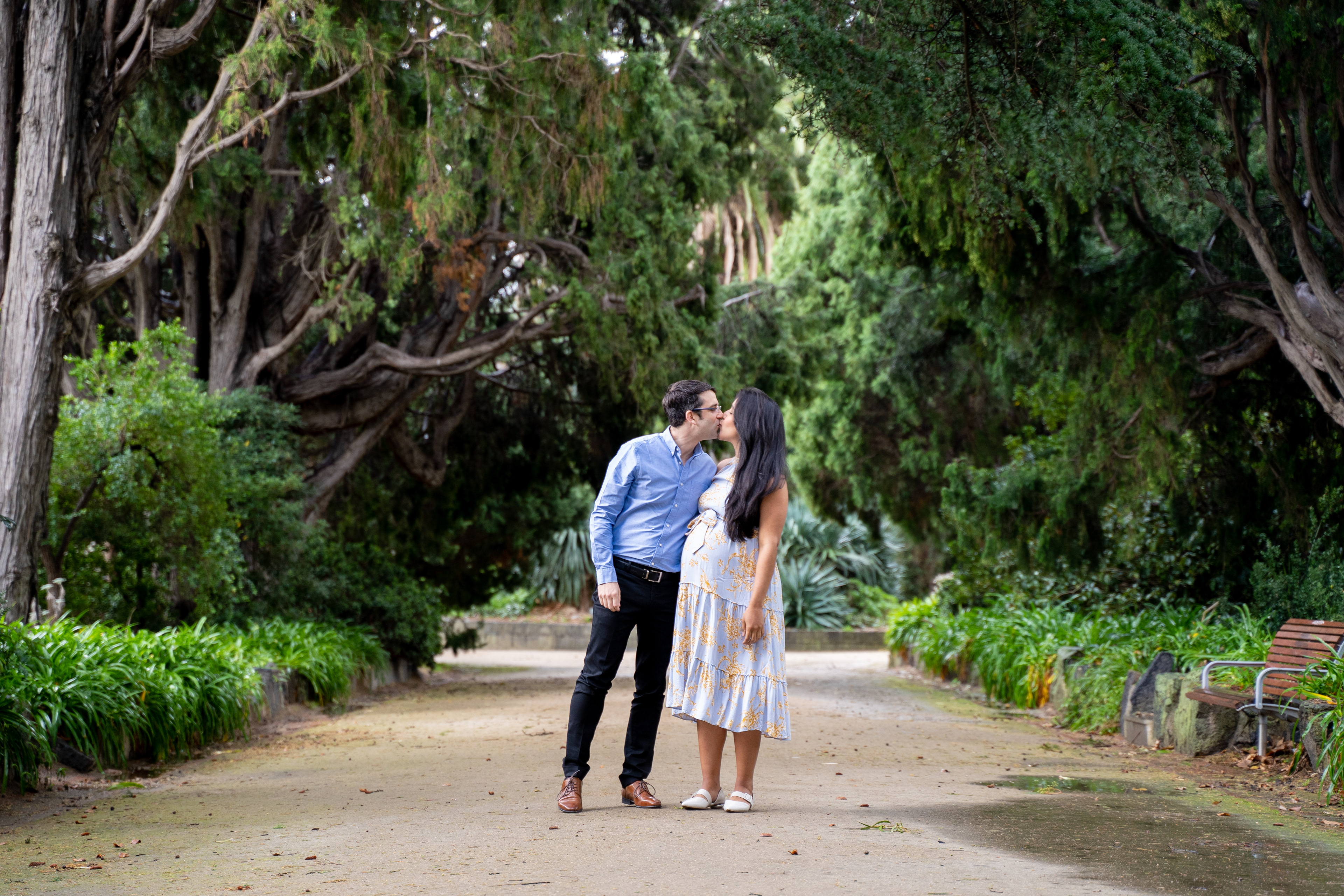 Couple walking together through a green park