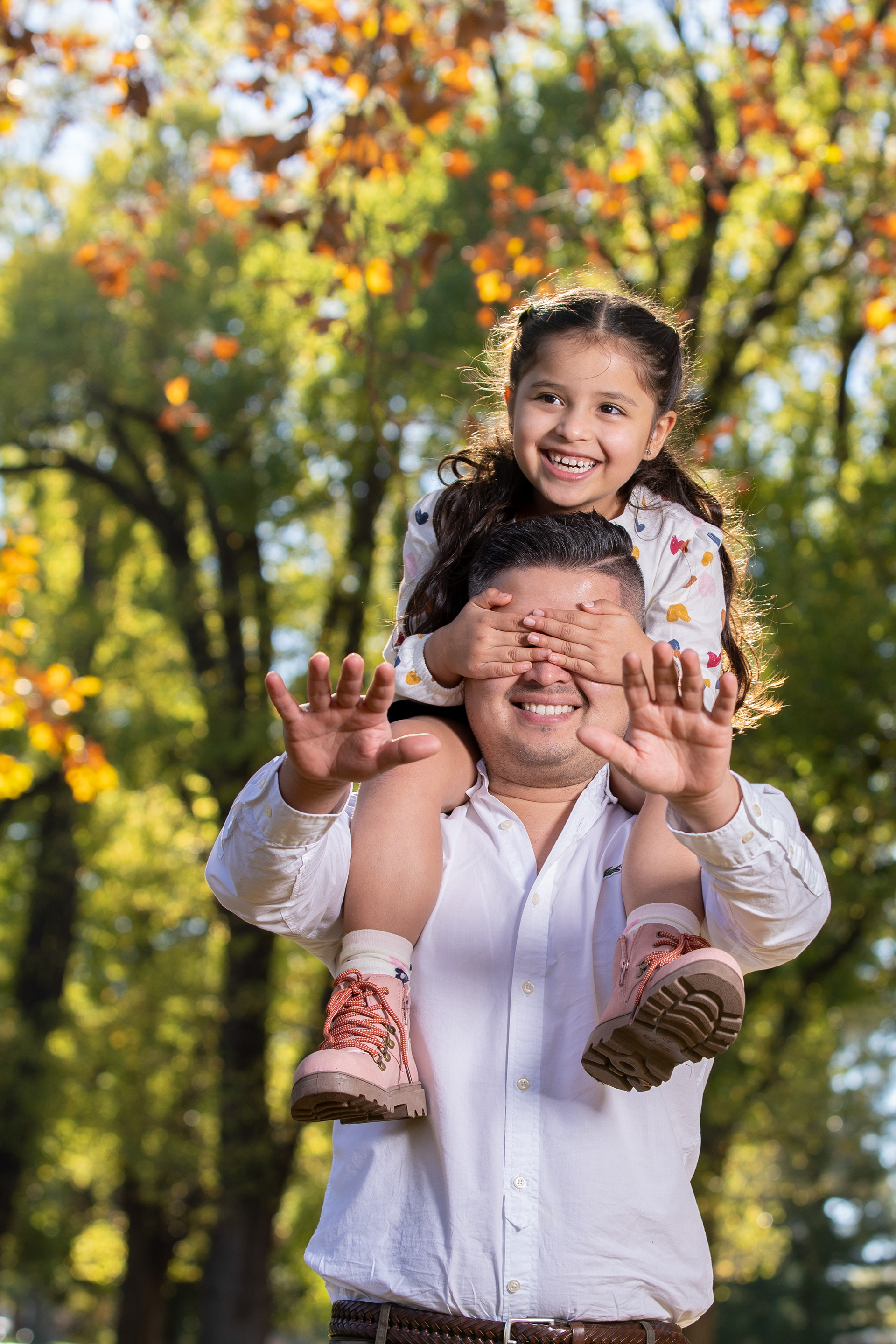 Parent and child standing beside a tree