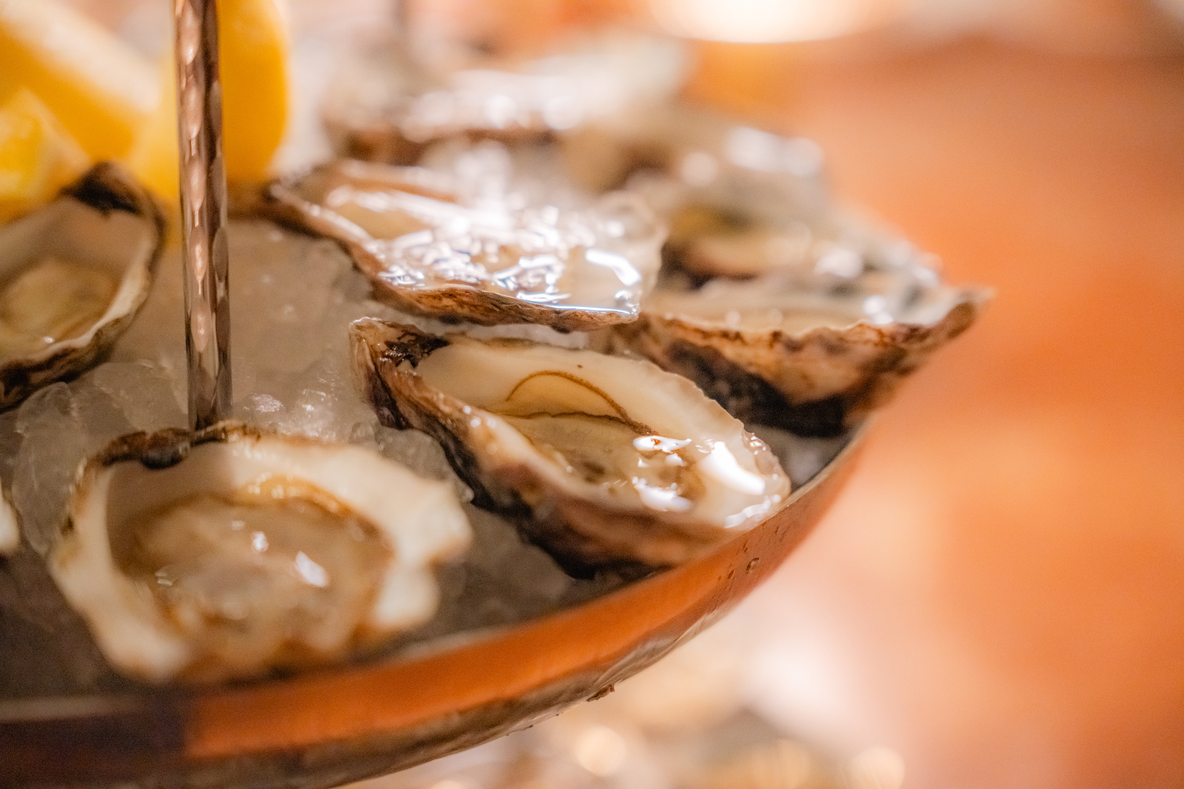 Oysters on a serving stand with wine in the background