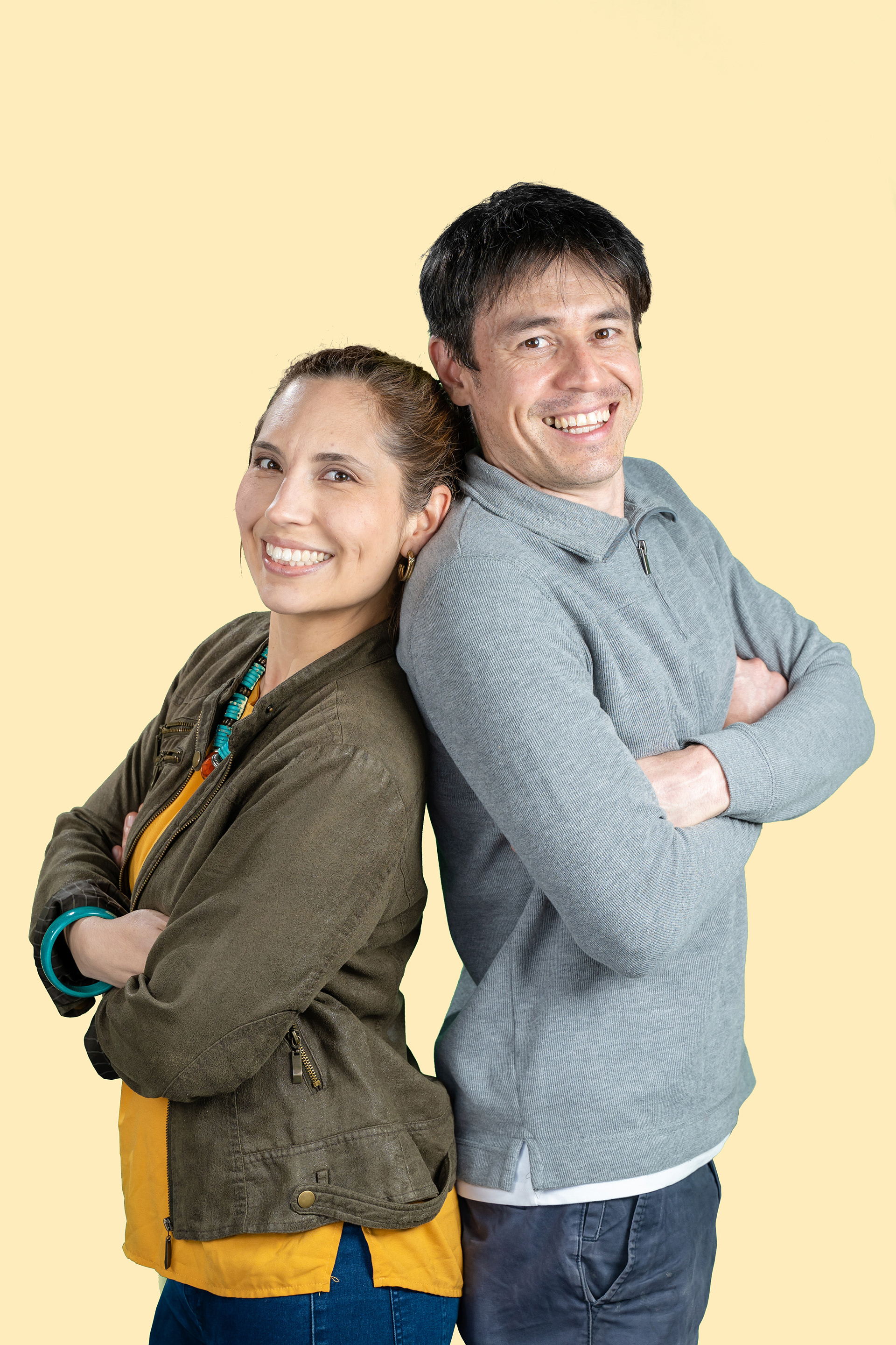 Couple standing together against a yellow studio background