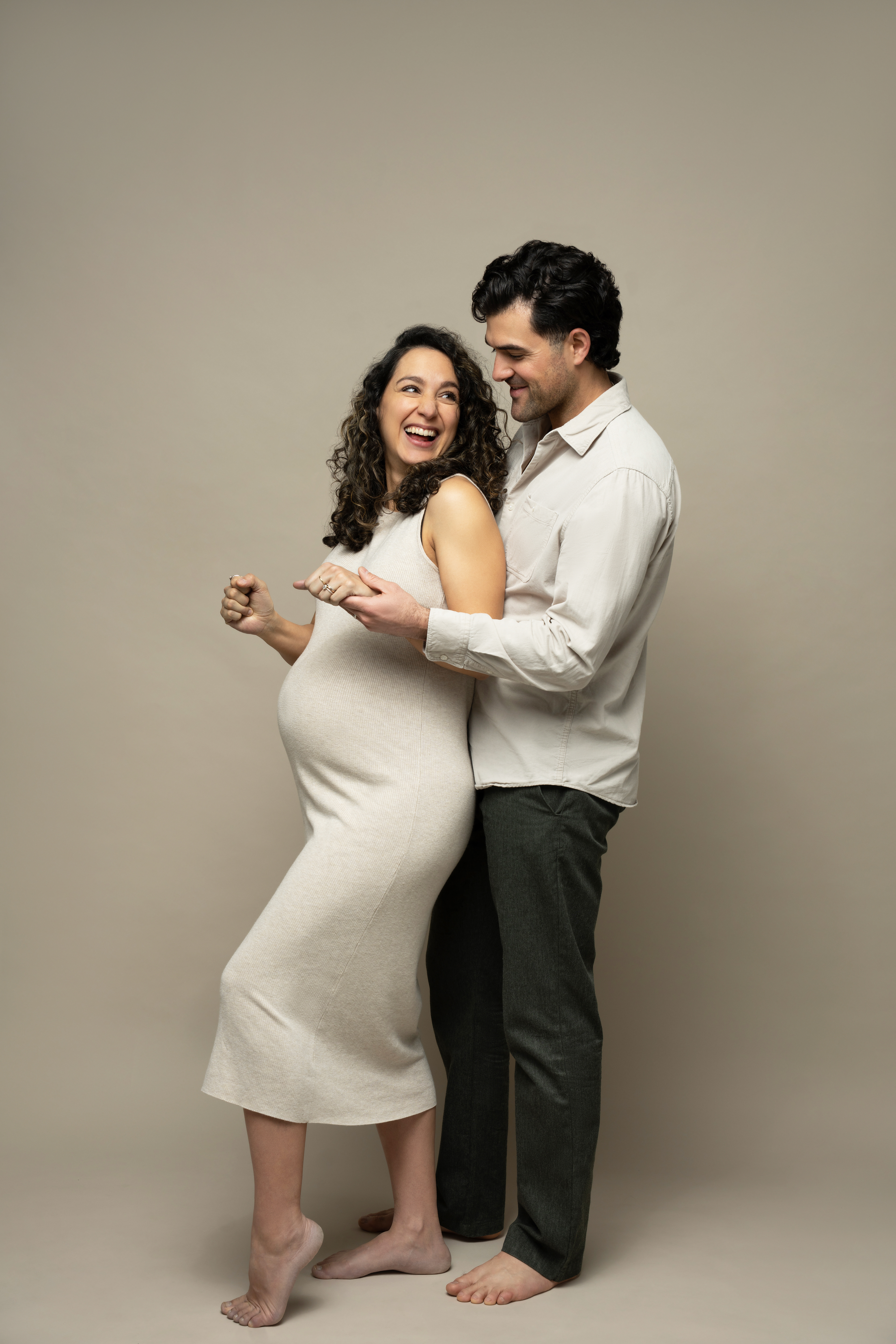 Couple standing close together against a neutral backdrop