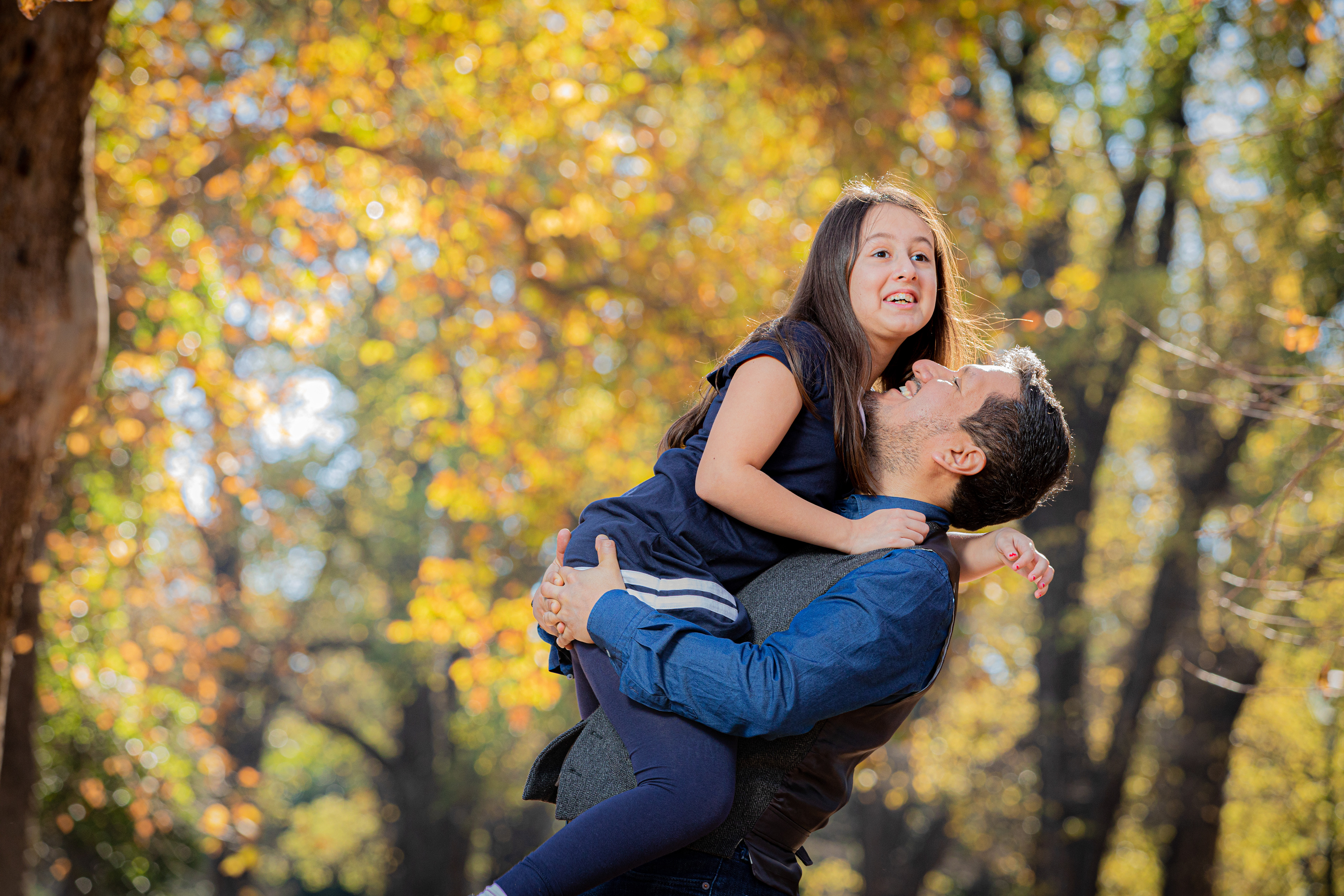 Parent holding a baby in warm autumn light