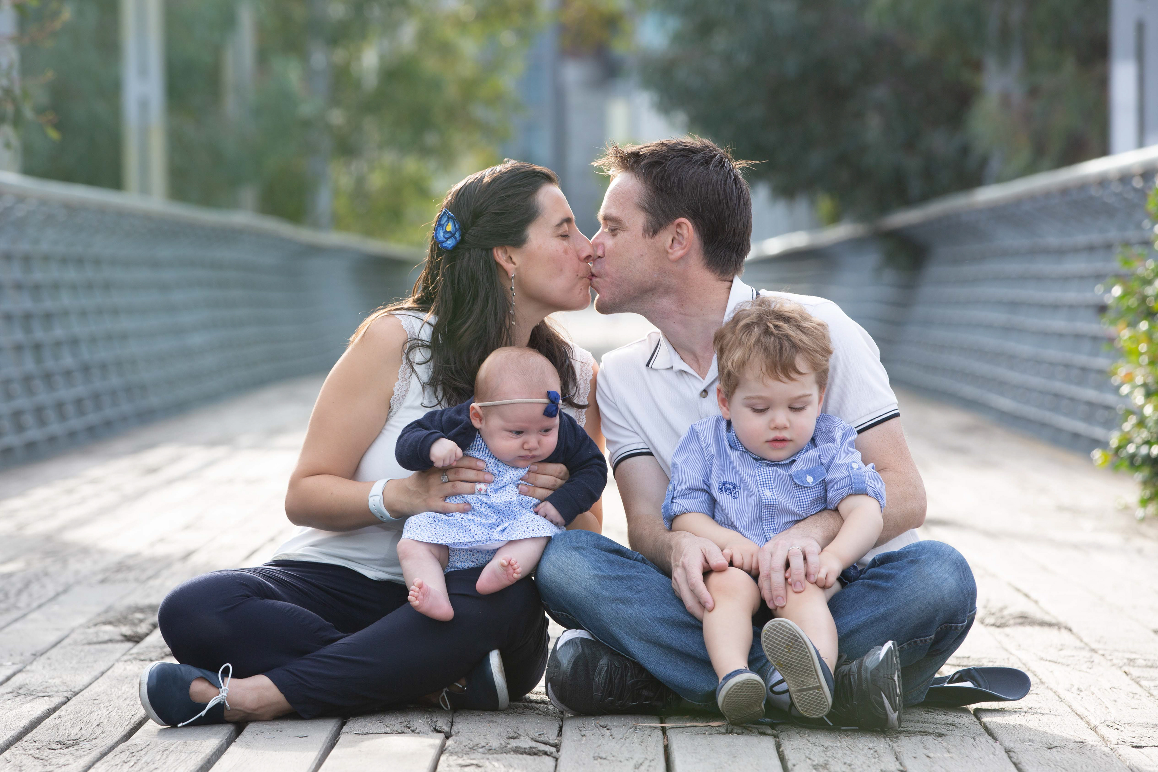 Family sitting together on a pedestrian bridge