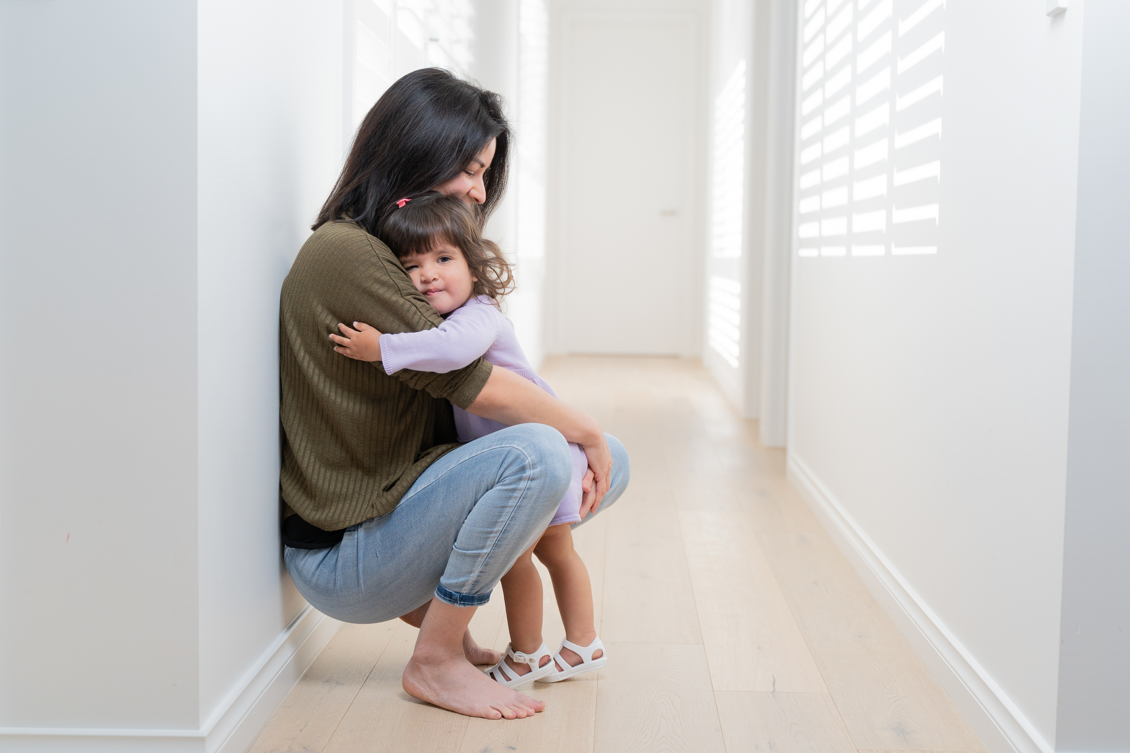 Parent holding a toddler in a bright room