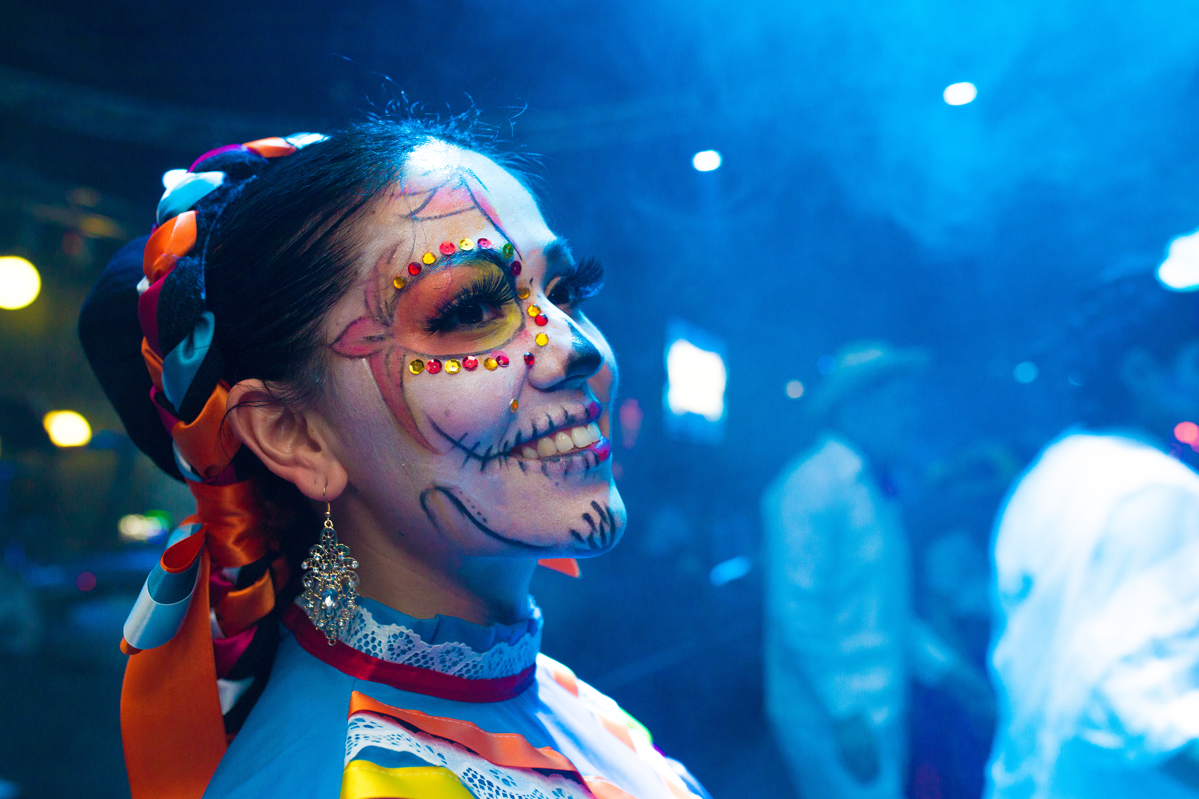 Guest wearing colourful skull face paint at an event