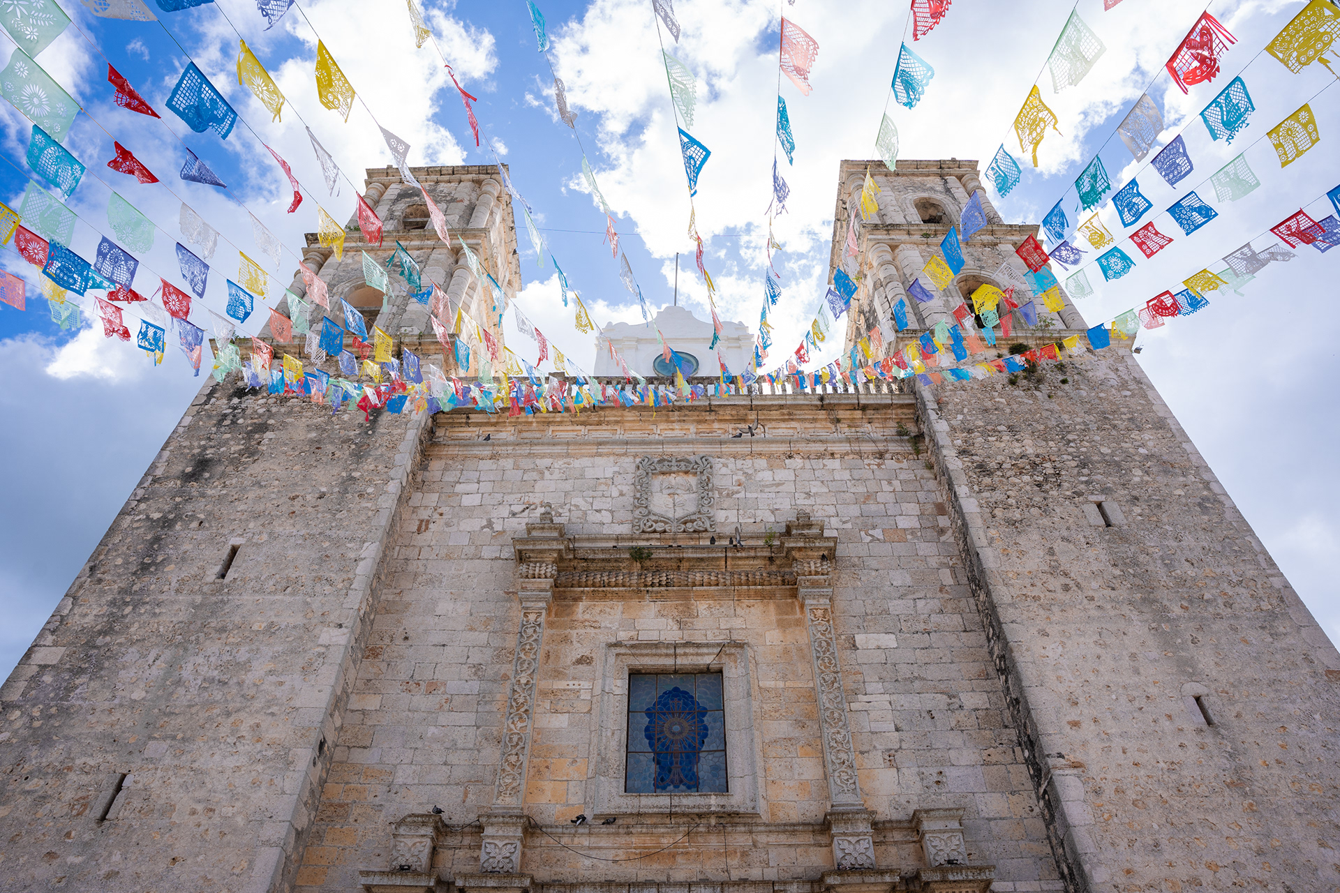 Historic church facade beneath colourful hanging decorations