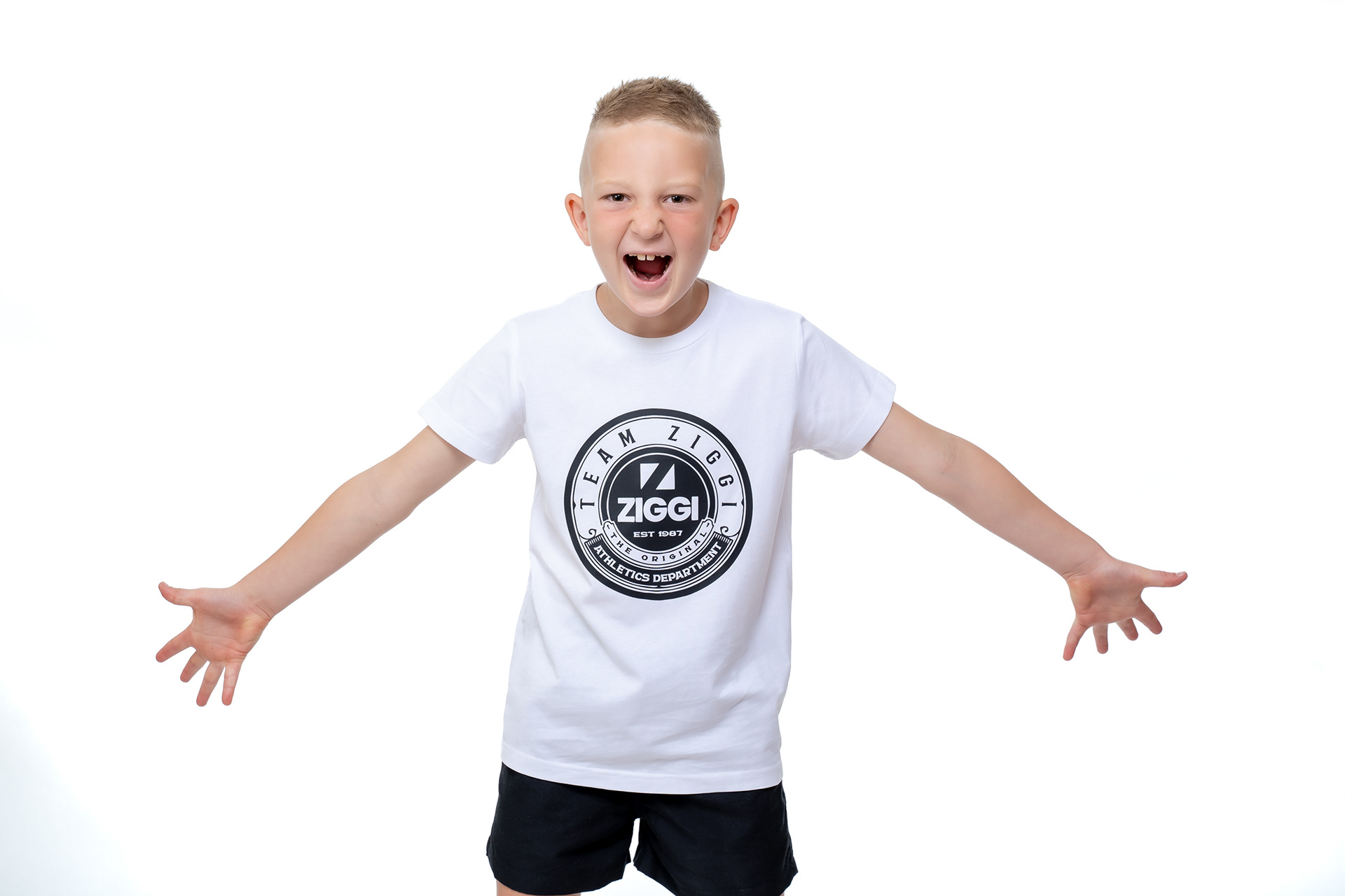 Child in a white sports T-shirt with arms outstretched
