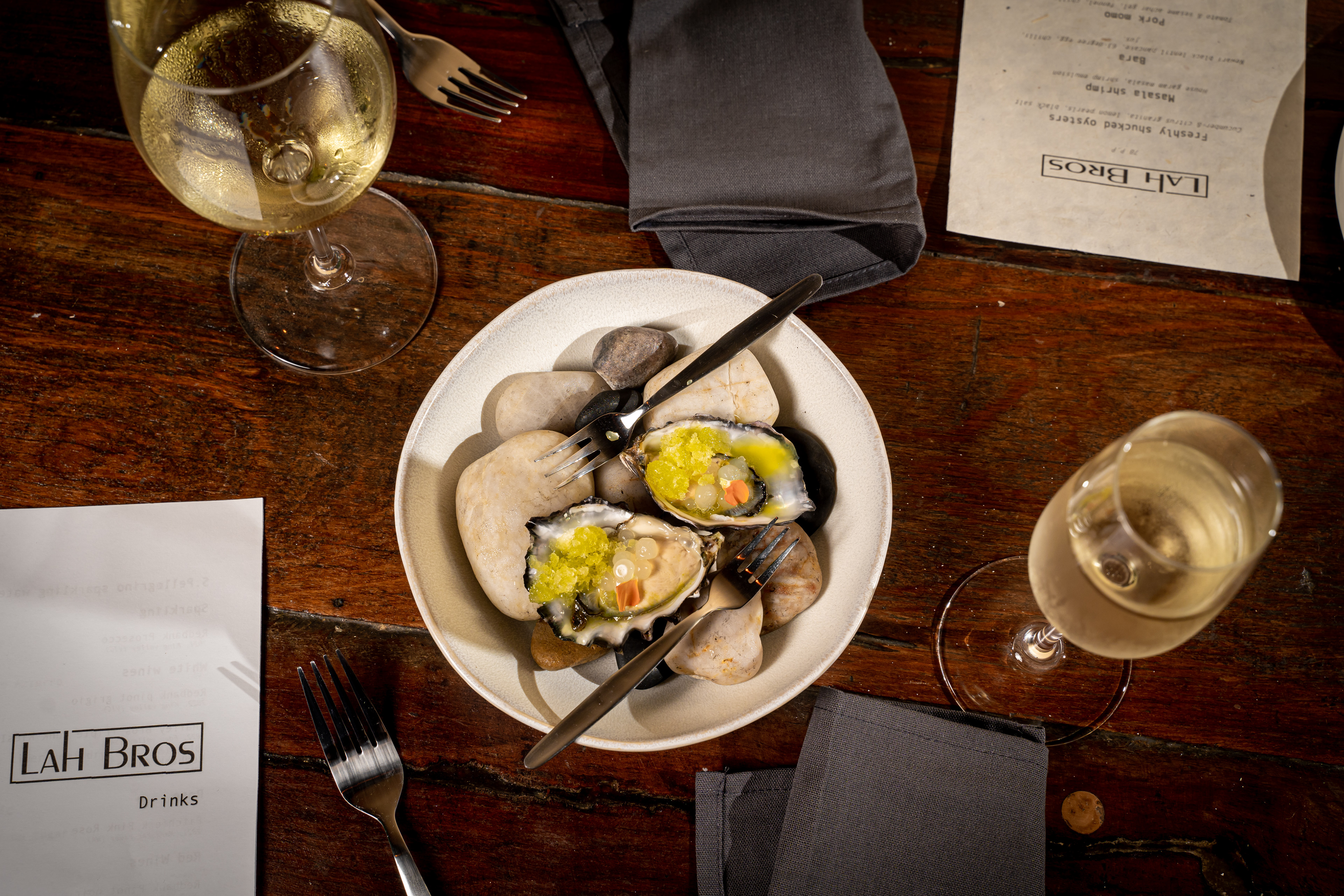 Overhead view of a restaurant table setting with bread and wine