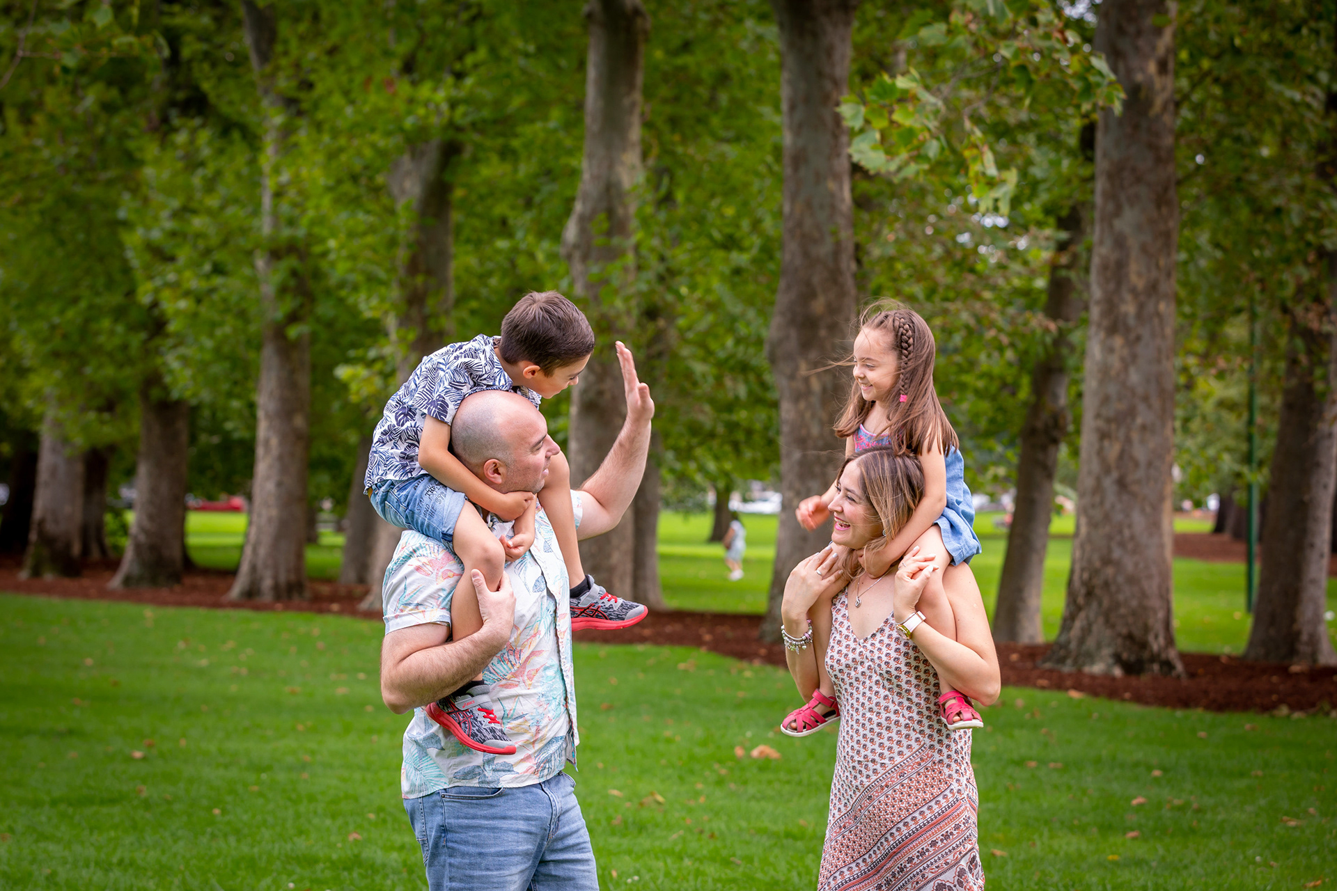 Family relaxing on a picnic blanket beneath trees