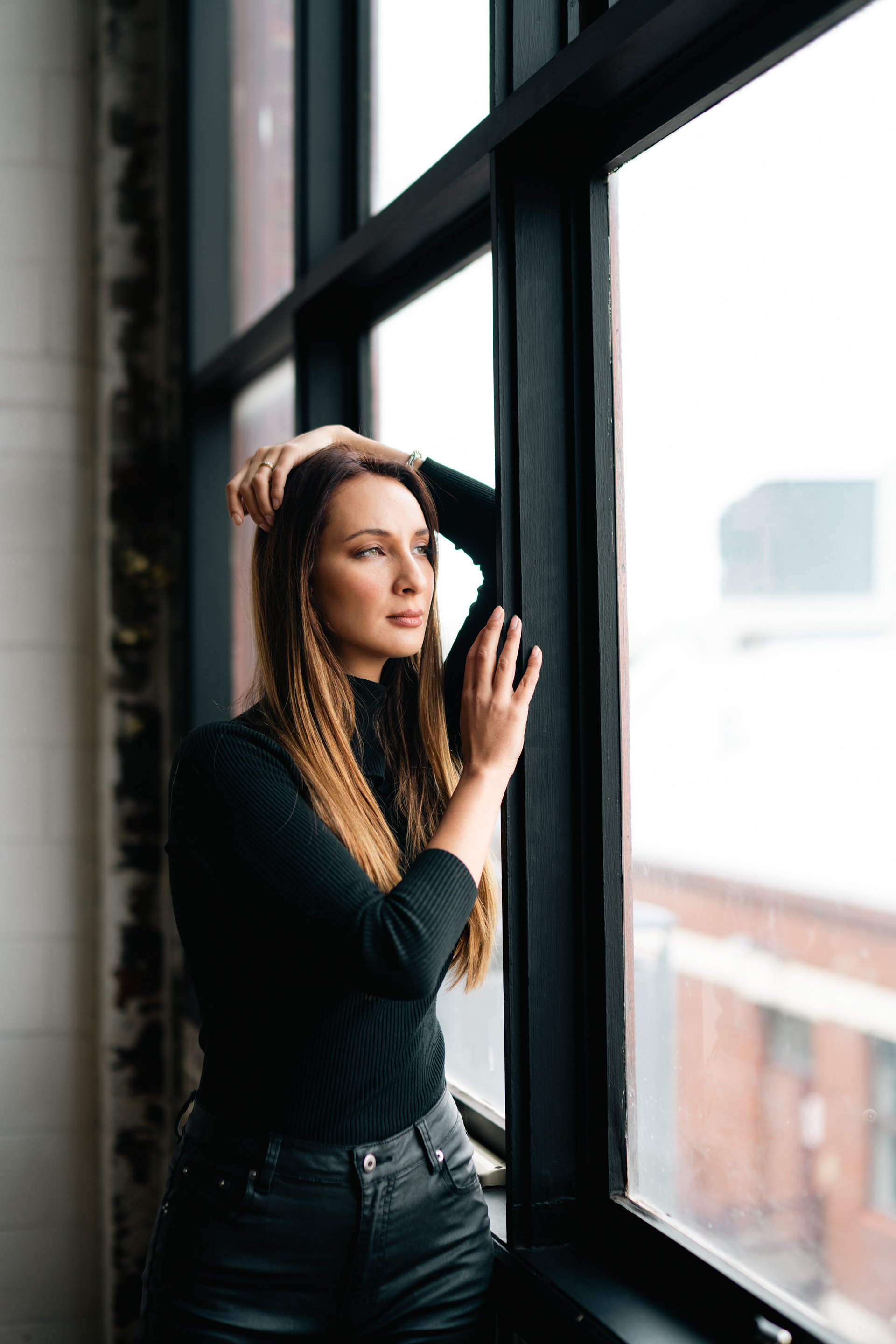 Portrait leaning beside a large studio window