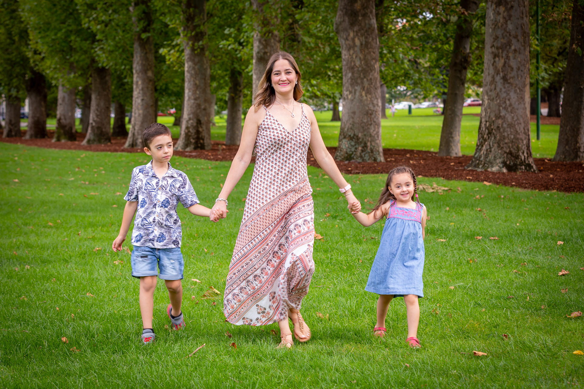 Full-length maternity portrait in a tree-lined park